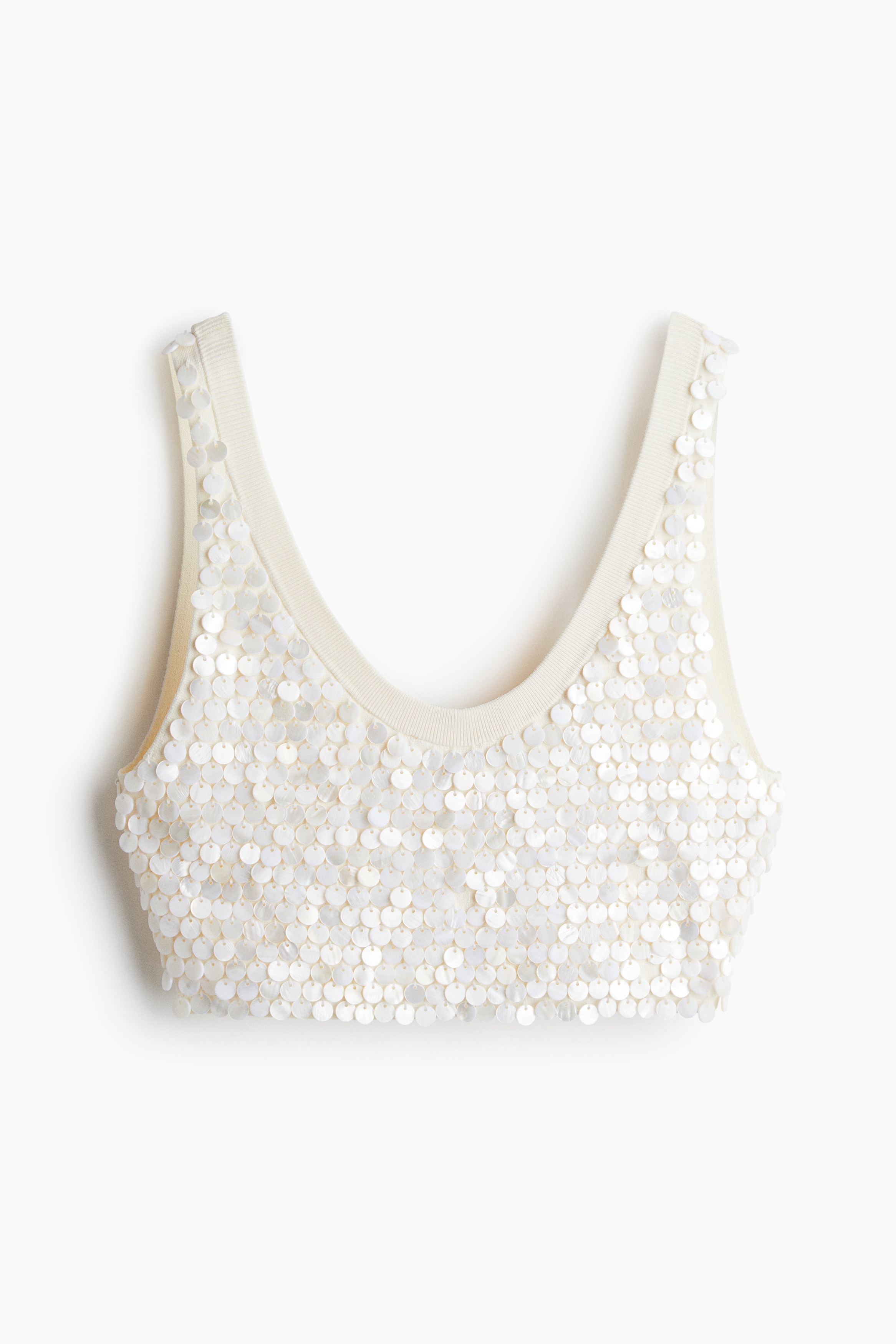 촘촘한 비스코스 니트 소재의 피트되는 크롭트 탑. 펄감 있는 우아한 앞면 아플리케 장식. 와이드한 어깨 스트랩. 앞뒷면이 스쿱넥으로 마감됨. 이미지