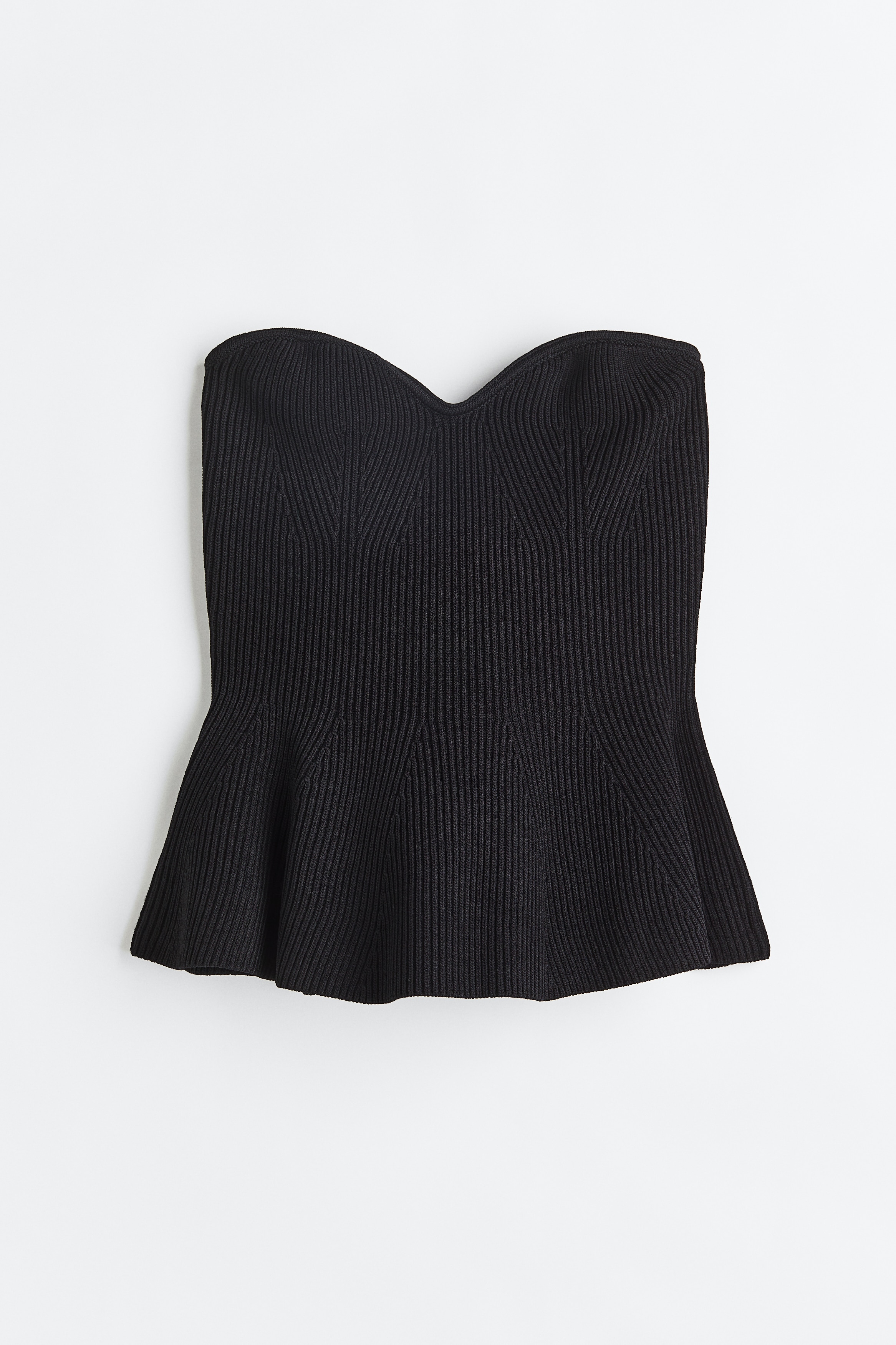 부드러운 골지 니트 소재으 피트되는 슬리브리스 탑. 스위트하트 네크라인. 상단에 흘러내림 방지용 실리콘이 내장됨. 플레어 라인의 페플럼으로 마감된 하단. 새틴 안감 부착. 이미지