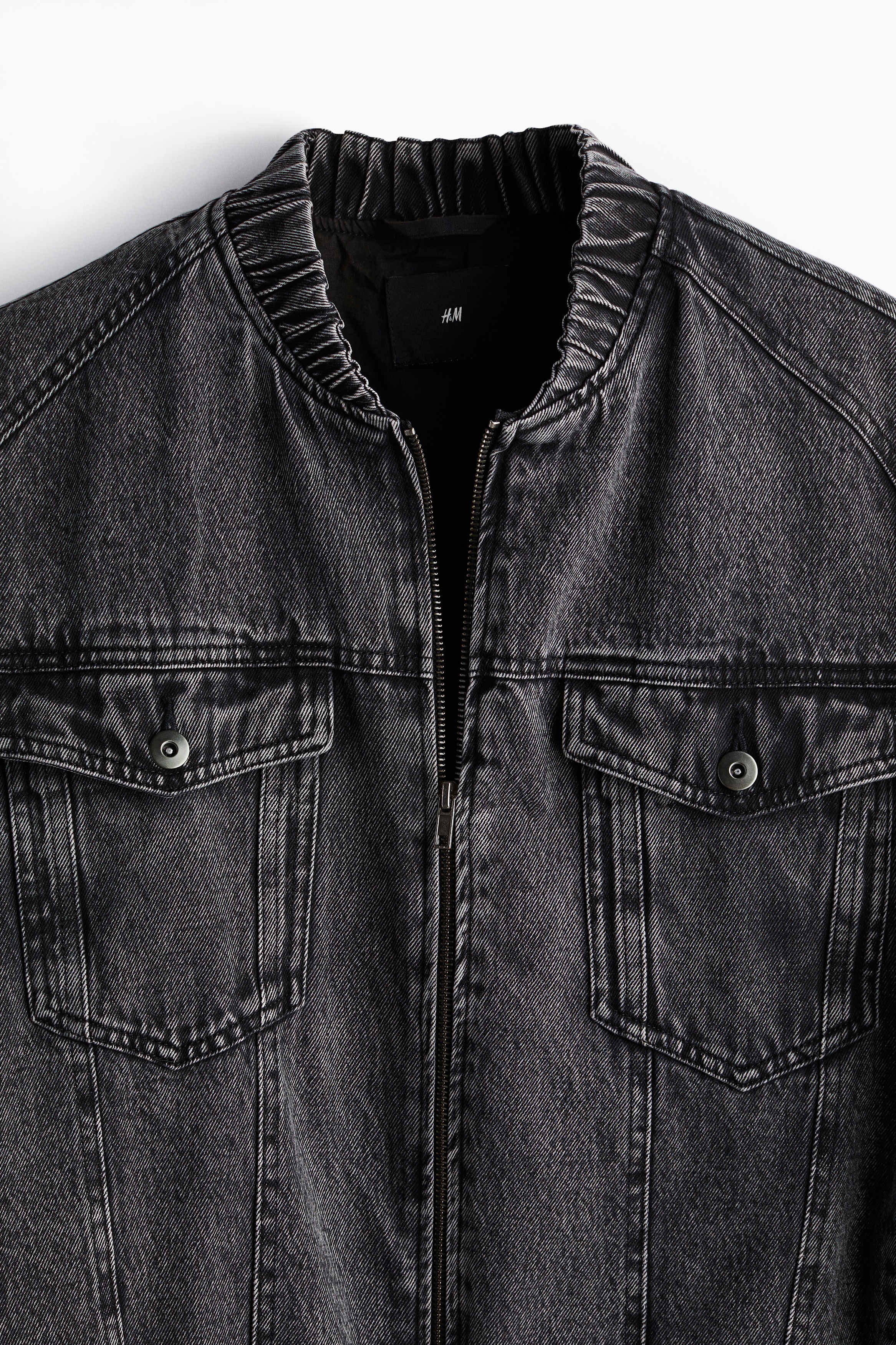 탄탄한 코튼 데님 소재의 집업 재킷. 밴딩이 내장된 하프넥. 뒷면 요크 디테일. 스냅버튼으로 여닫는 가슴 플랩포켓. 드롭 숄더. 긴소매. 밴딩이 내장된 소맷단과 아랫단. 넉넉하지만 오버사이즈보다는 약간 피트되는 루즈핏 실루엣. 안감 부착. 이미지