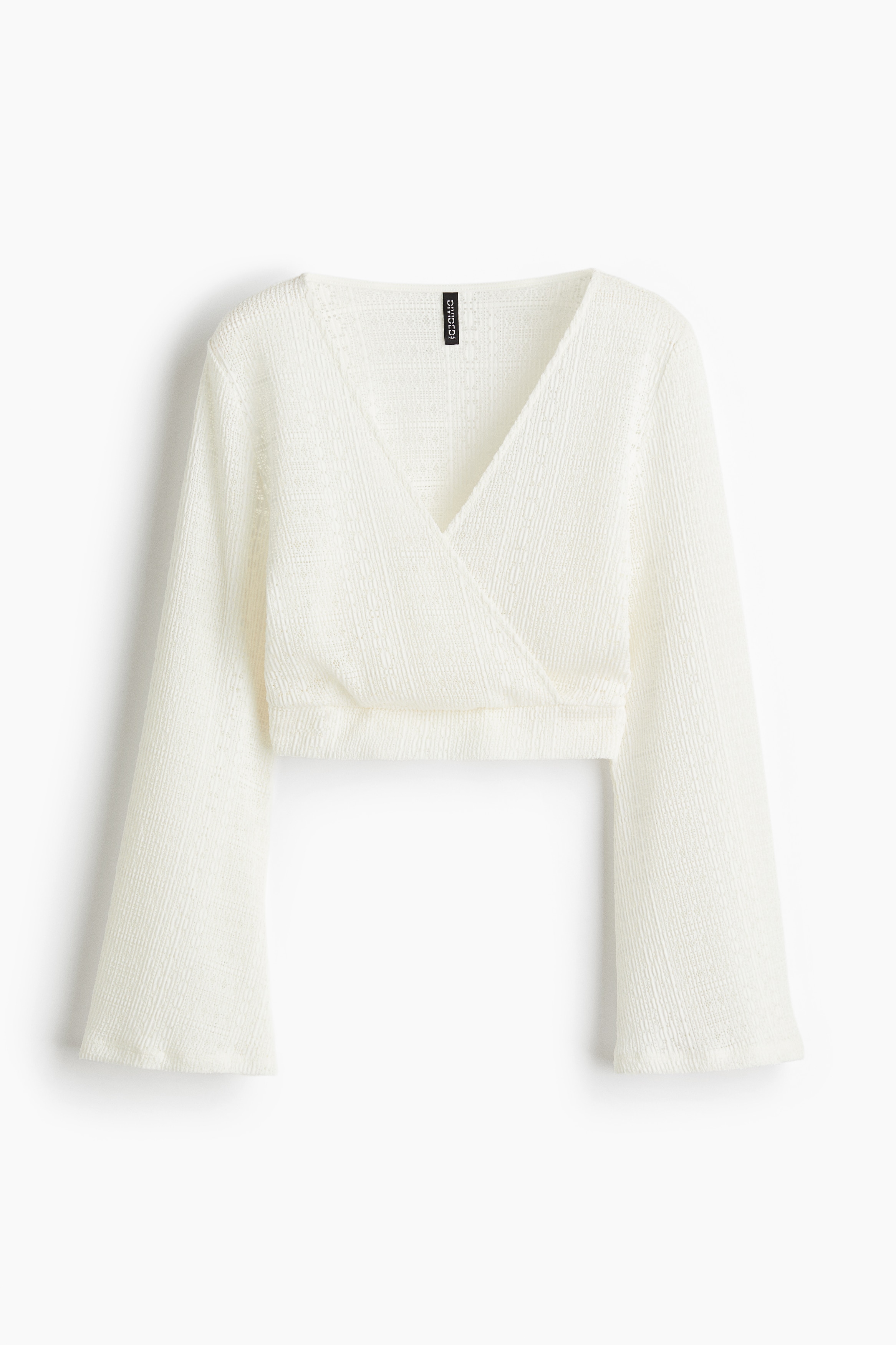 레이스 느낌을 주는 부드러운 저지 소재의 V넥 크롭트 탑. 앞면이 랩스타일로 고정됨. 세미 플레어 라인의 긴소매. 이미지