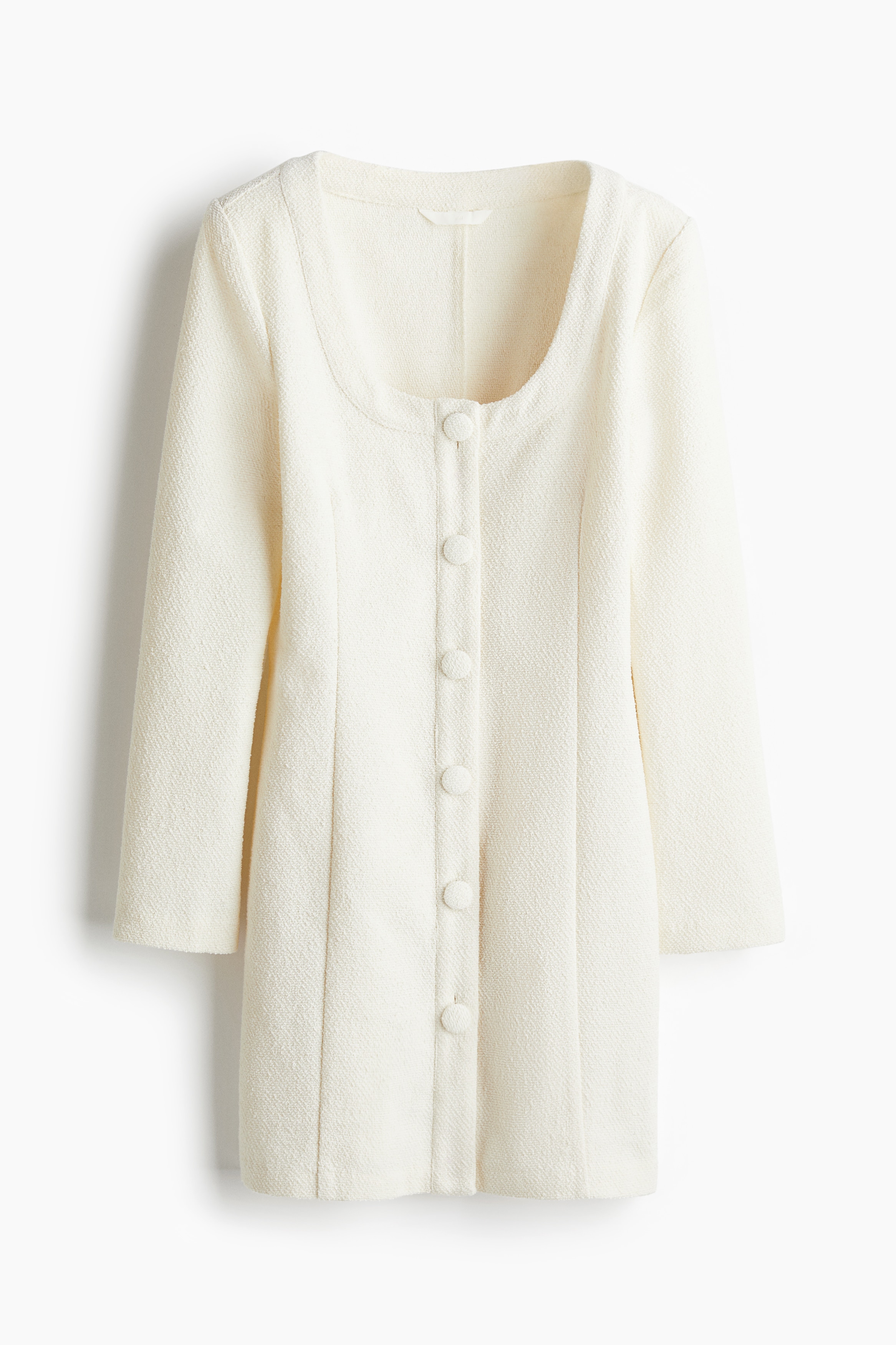 텍스처가 있는 우븐 소재의 피트되는 미니 원피스. 스쿱넥. 앞면 커버드 버튼. 숄더 패드 내장. 긴소매. 앞뒷면에 눈에 띄는 솔기가 있음. 안감 생략. 이미지