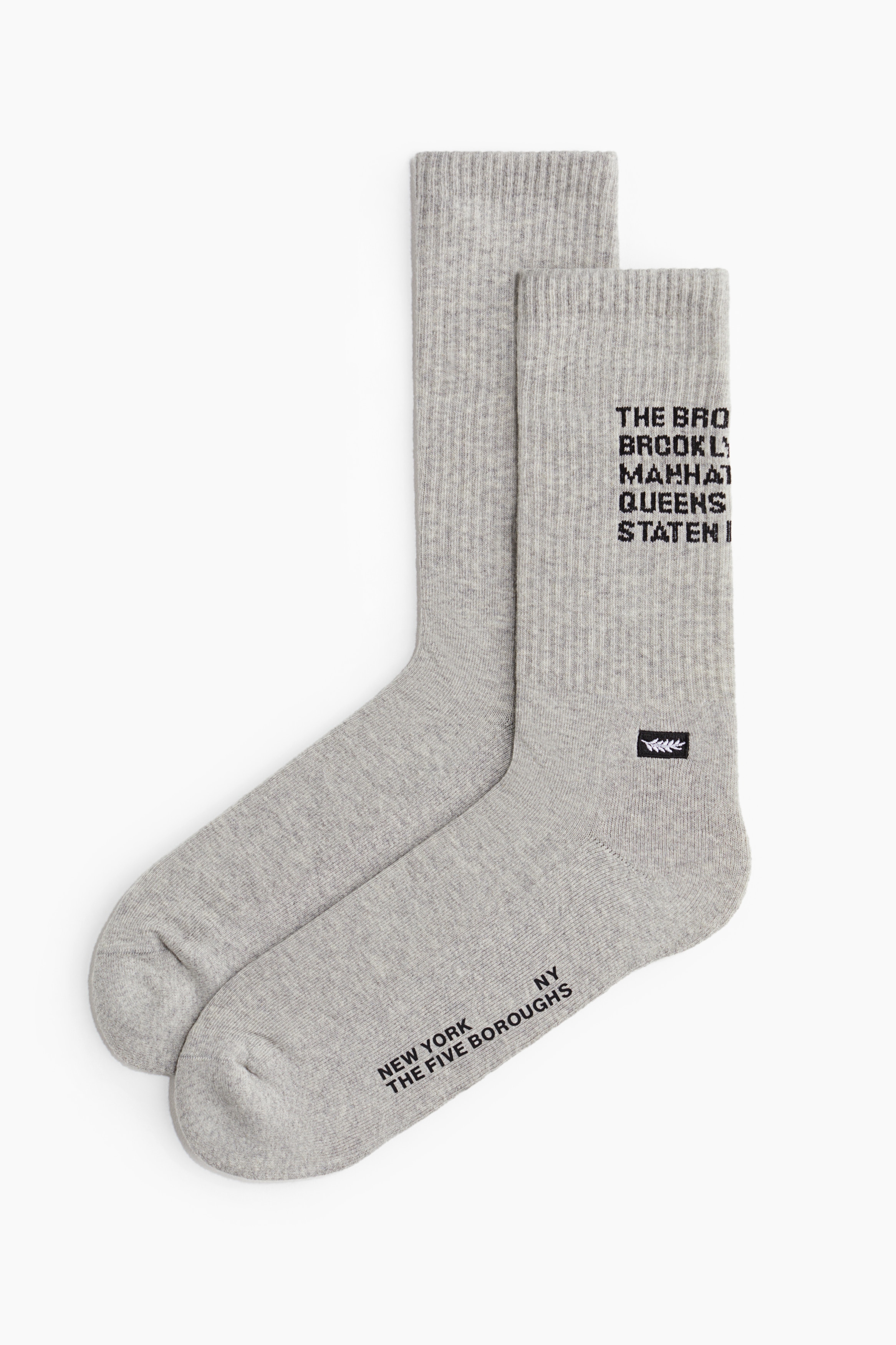 장식 디테일이 있는 부드러운 코튼 혼방 소재의 파인니트 양말. 긴 발목 부분이 리브드 마감됨. 이미지