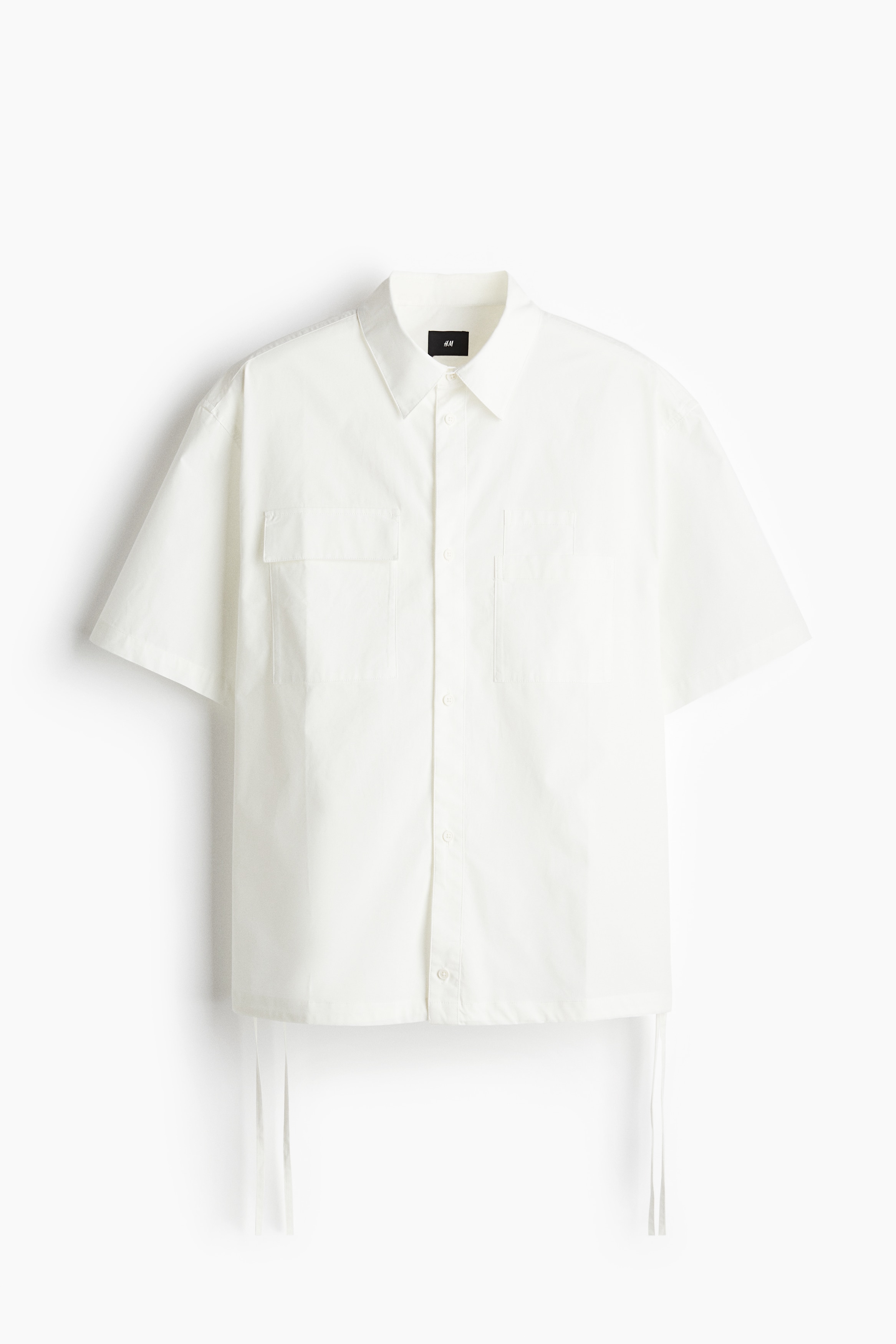 부드러운 코튼 소재의 반소매 유틸리티 셔츠. 턴다운 칼라. 버튼단이 있는 클래식 프런트 스타일. 뒷면 요크. 다양한 디자인의 가슴 포켓 3개. 드로스트링으로 핏을 조절하는 스트레이트 헴라인. 넉넉하지만 오버사이즈보다는 약간 피트되는 루즈핏 실루엣. 이미지