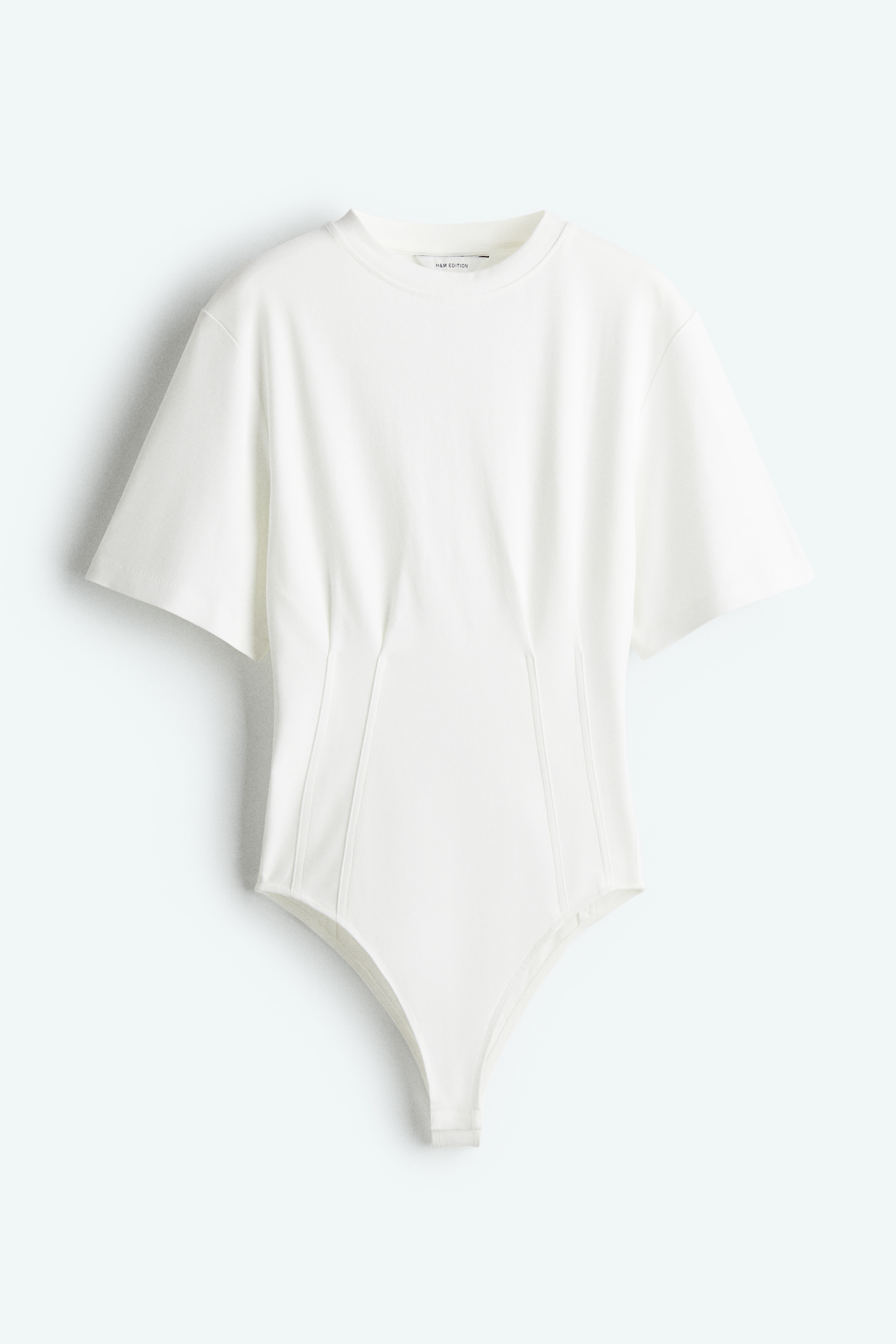 톡톡한 코튼 더블 저지 소재의 티셔츠 스타일 바디수트. 크루넥. 세미 드롭 숄더. 앞뒷면에 다트를 잡아 허리 실루엣을 살린 디자인. 아랫부분 히든 스냅버튼. 이미지