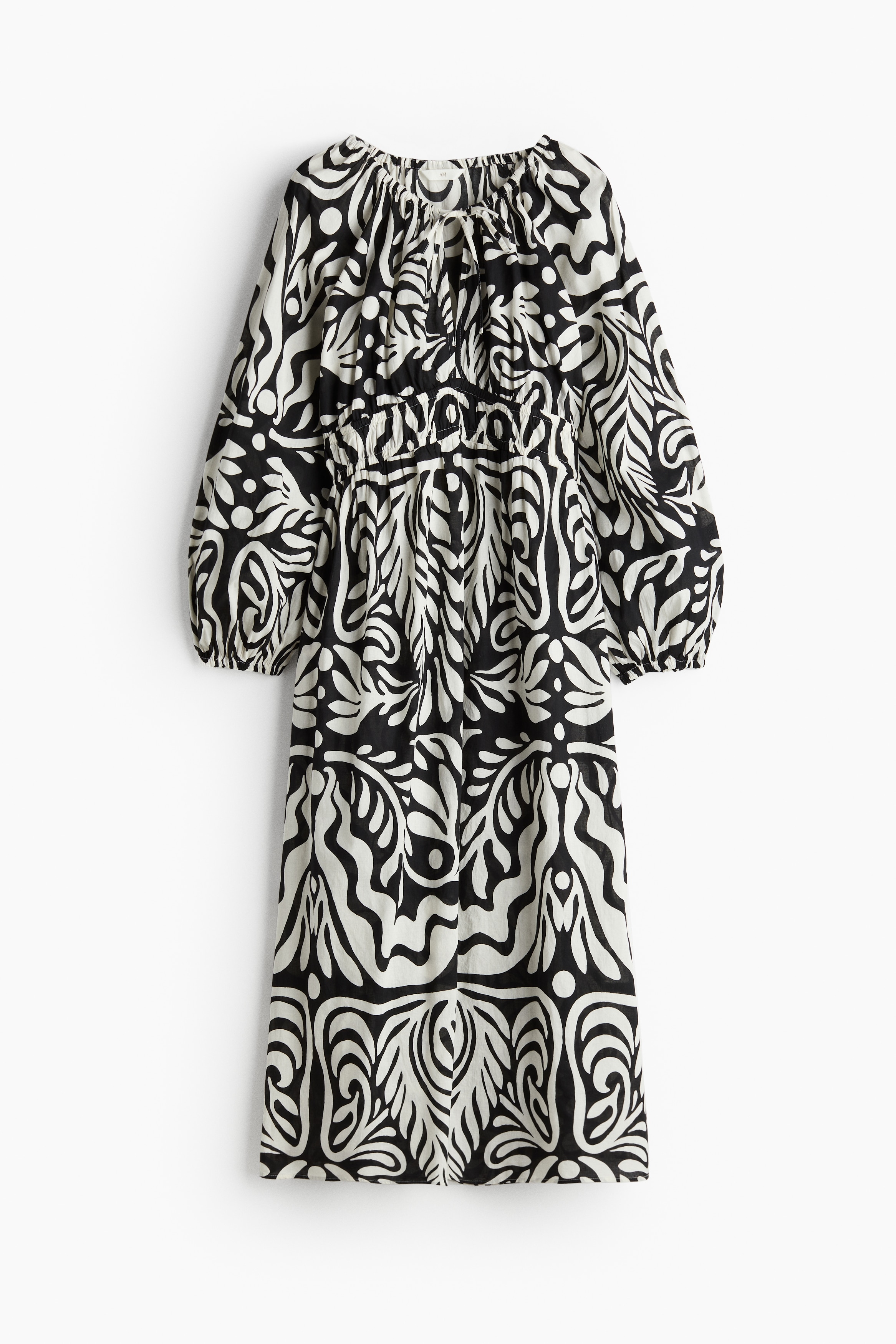 가벼운 코튼 소재의 미디 원피스. 루즈핏. 드로스트링이 있는 네크라인. 앞면 상단에 V자 트임이 있음. 래글런 스타일의 긴 벌룬 소매. 신축성 소맷단. 허리 부분이 2줄로 가늘게 밴딩처리됨. 안감 생략. 이미지