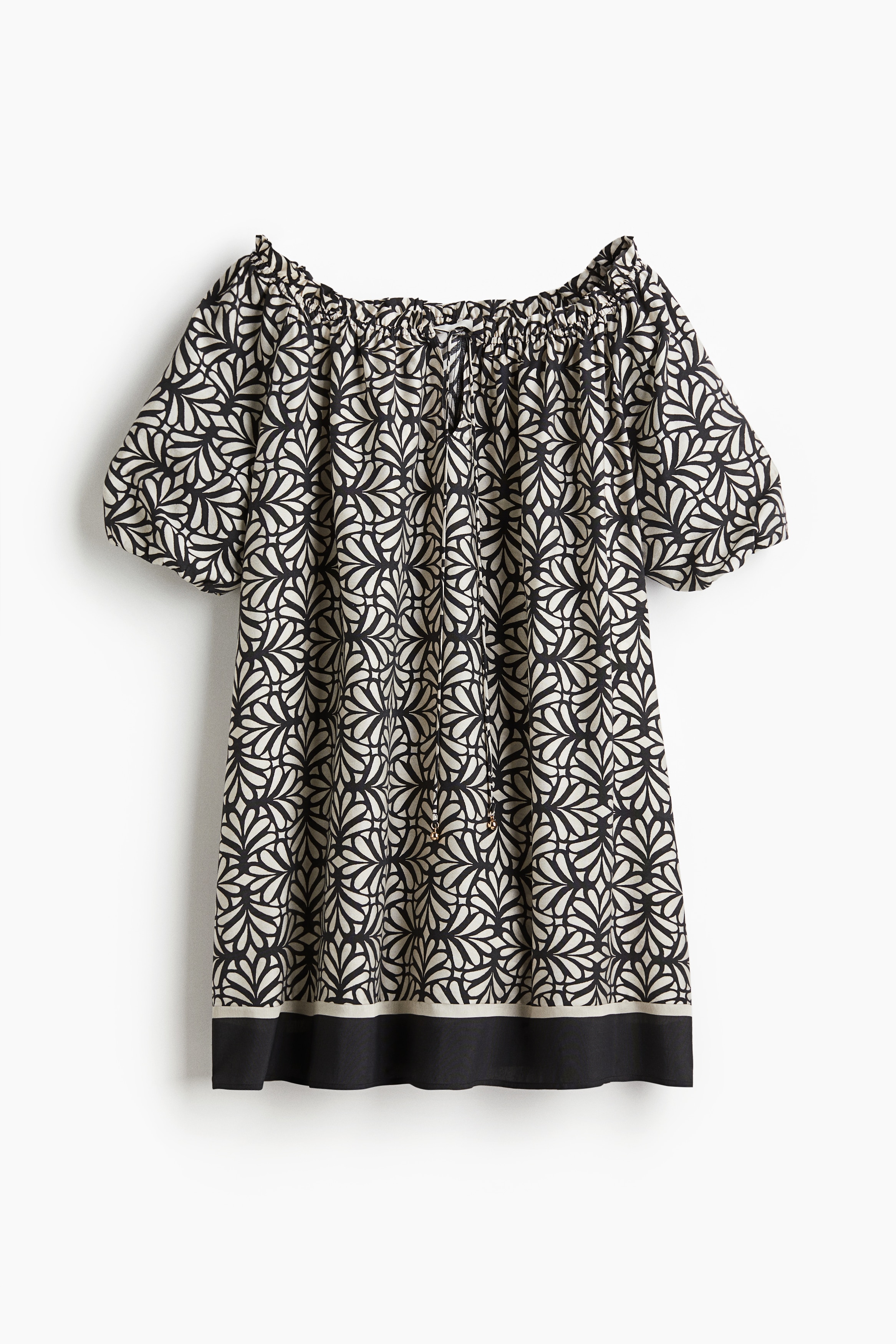 우븐 소재의 A라인 미니 드레스. 신축성 있으며, 깊게 파인 와이드넥이 짧은 프릴로 장식됨. 비즈로 마감된 가느다란 끈이 있는 앞면 V자 트임. 안감이 부착된 벌룬 스타일의 반소매. 이미지