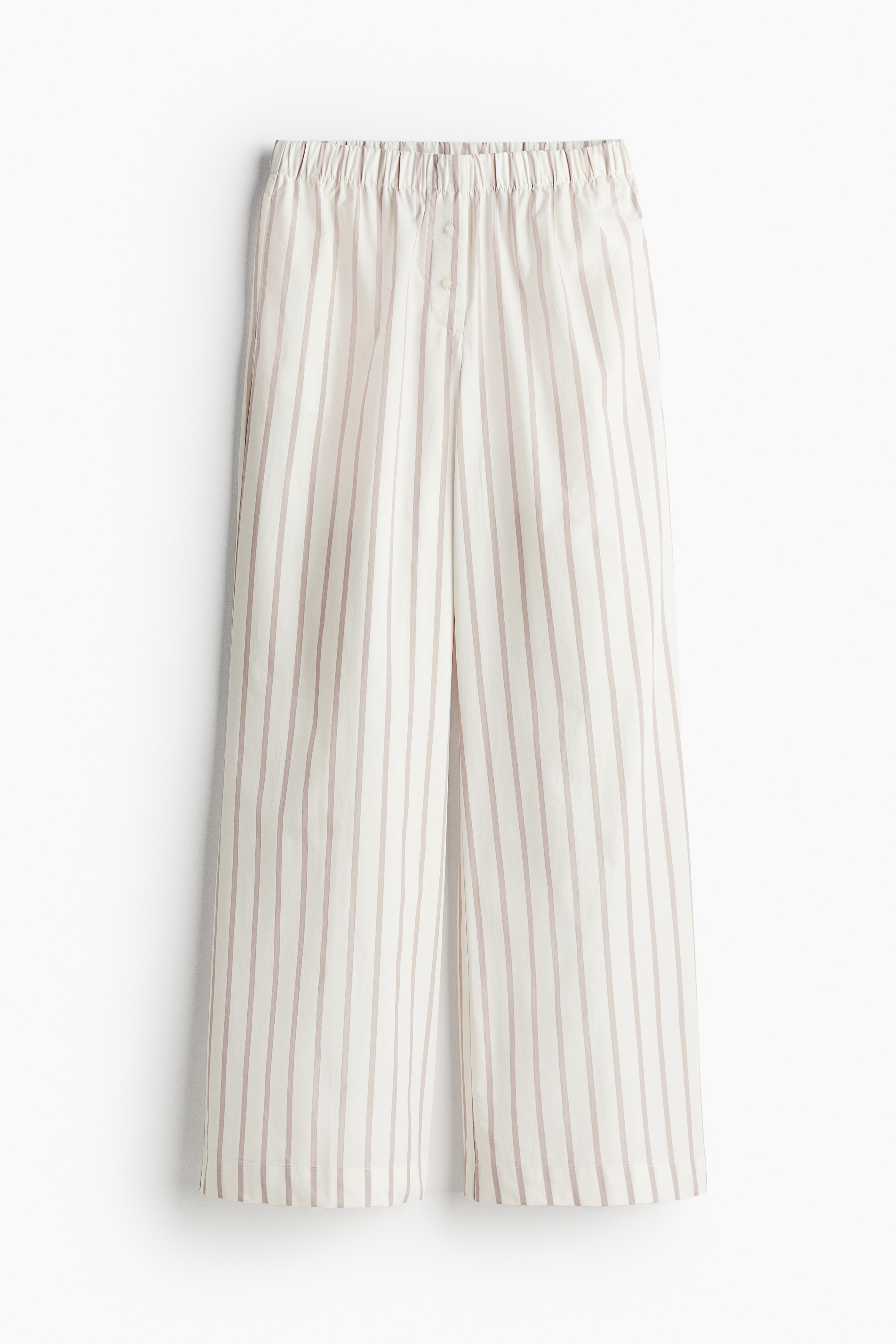 코튼 소재의 루즈핏 로라이즈 팬츠. 신축성 허릿단. 버튼이 있는 페이크 플라이. 옆면 히든 포켓. 이미지