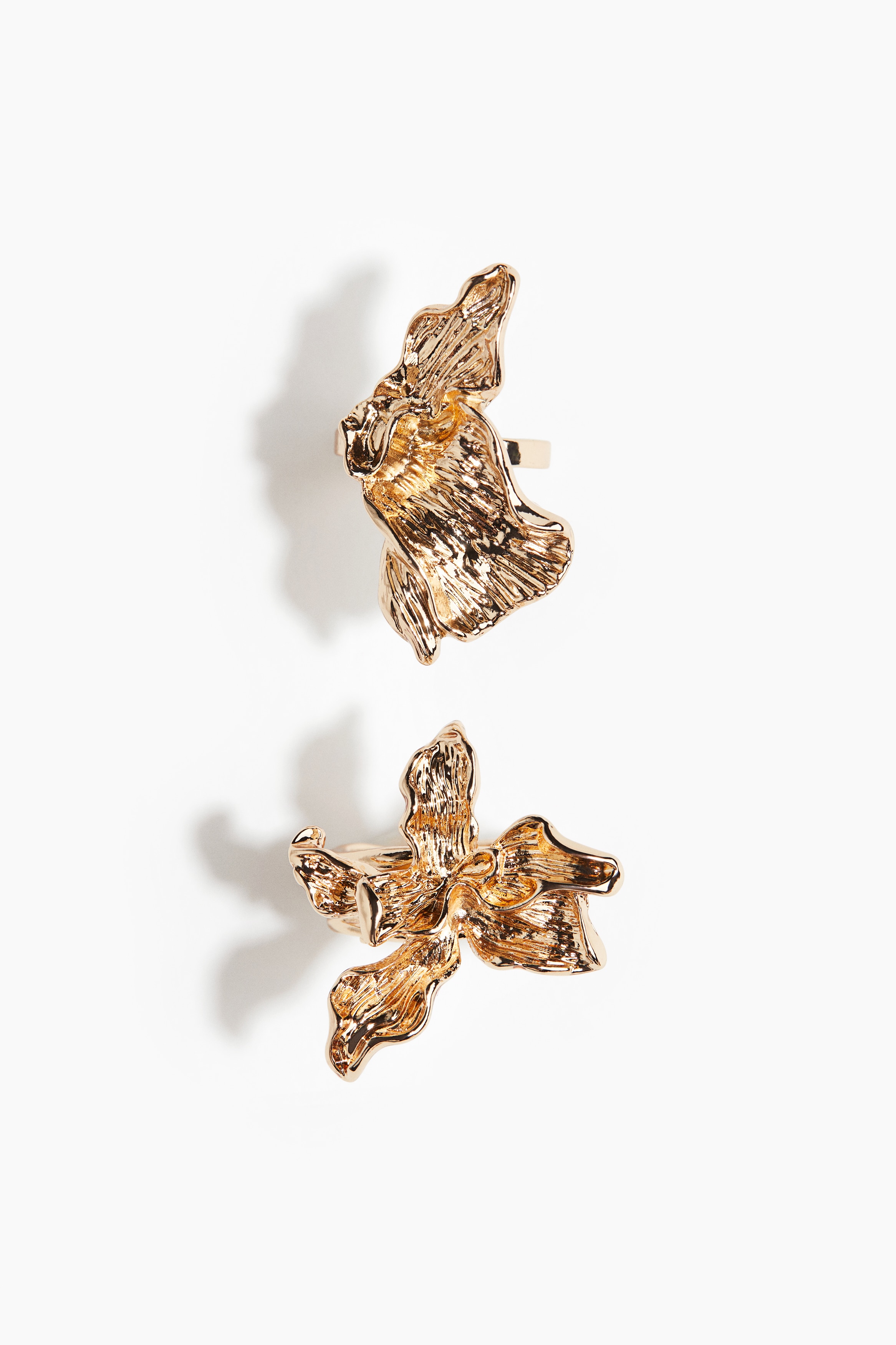 표면에 텍스처가 있는 유기적인 디자인의 금속 반지 세트. 이미지