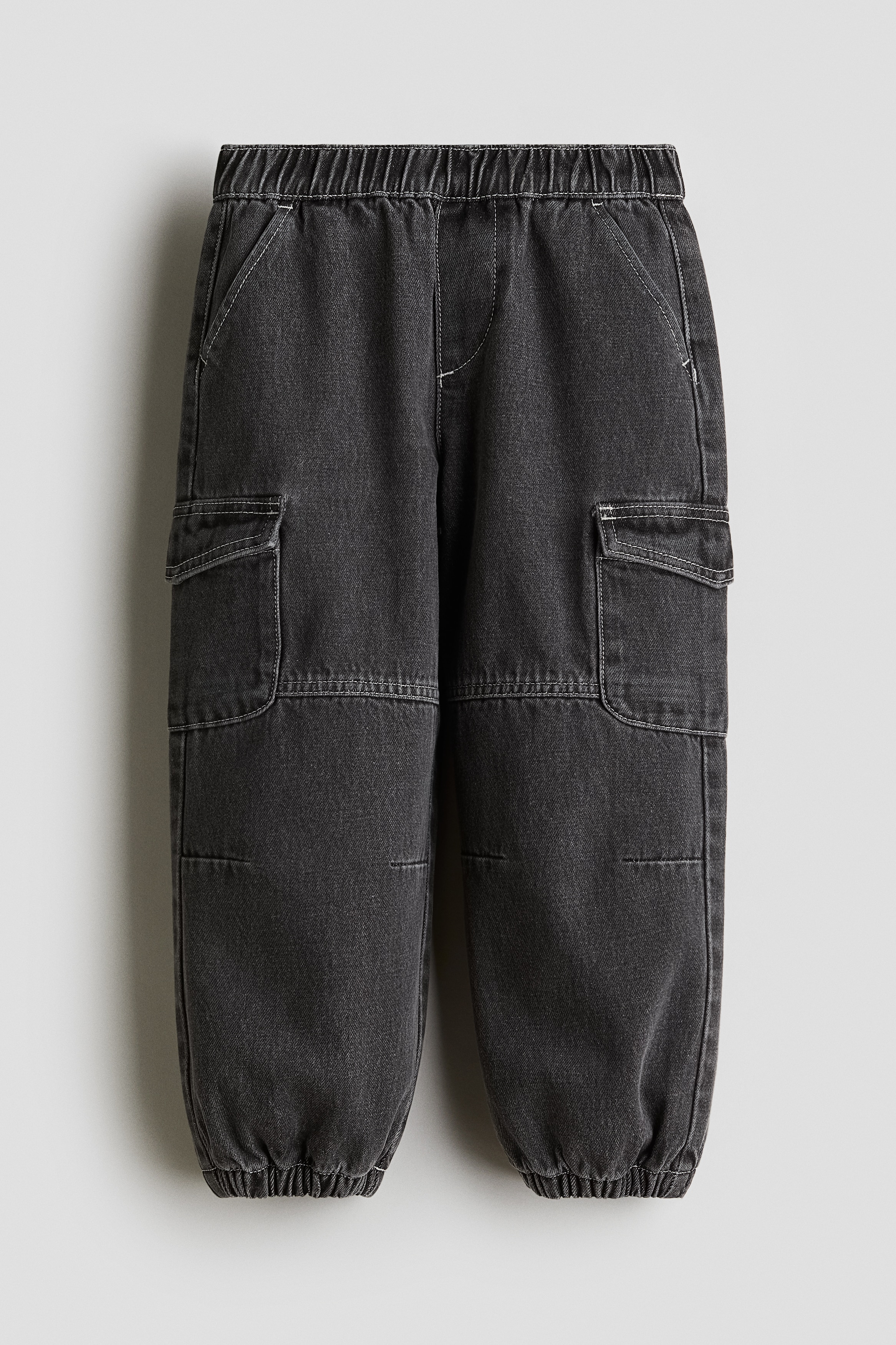 부드러운 코튼 데님 소재의 카고 스타일 조거 팬츠. 신축성 허릿단. 페이크 플라이. 사선 방향의 앞면 포켓. 다리 플랩포켓. 신축성 아랫단. 이미지