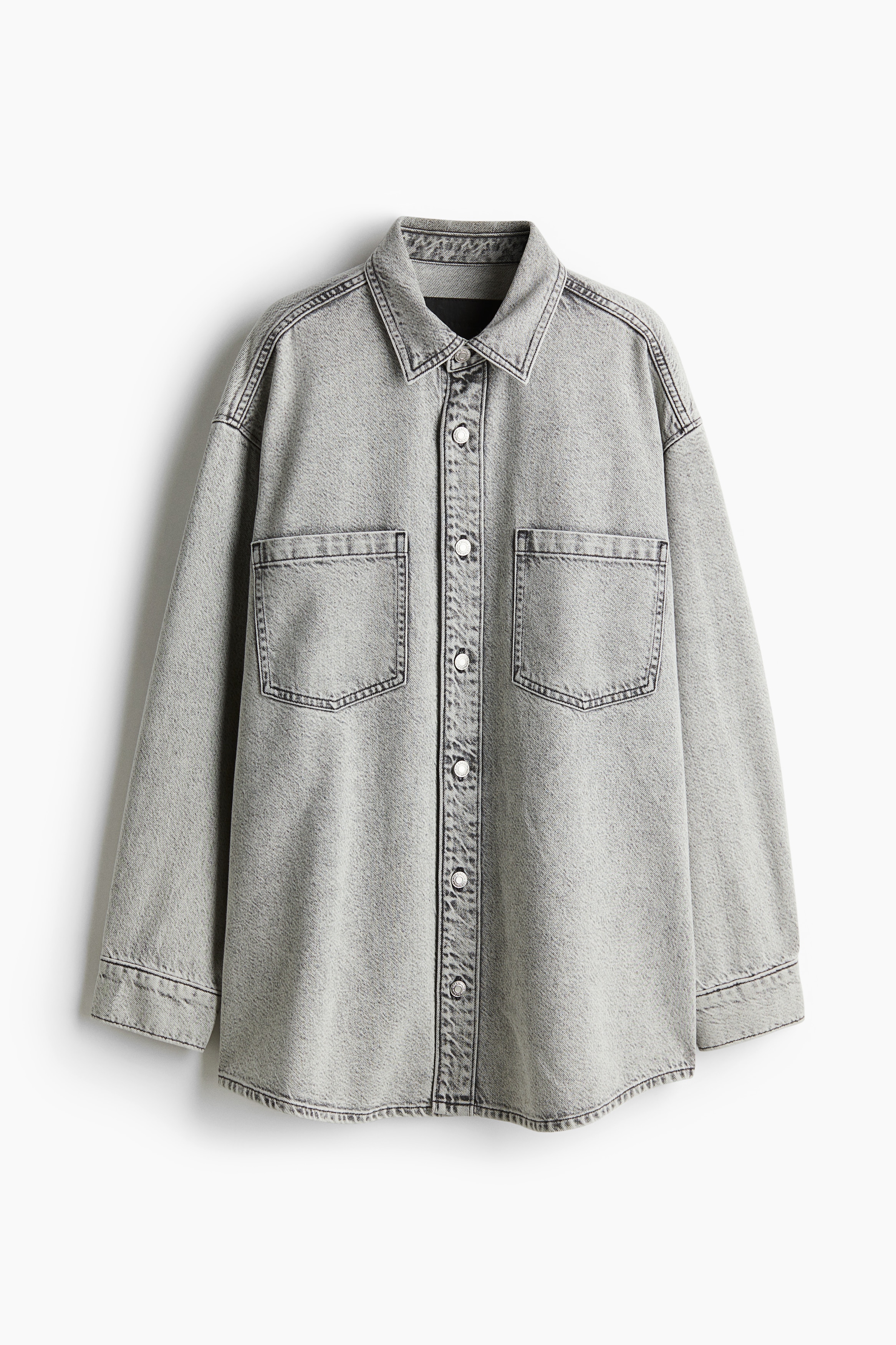 매우 부드럽고 깃털처럼 가벼운 데님 소재의 셔츠. 칼라와 앞면 버튼이 있음. 박스 플리츠가 잡힌 뒷면 요크 디테일. 루즈핏. 어꺠 솔기가 약간 앞면으로 배치된 디자인. 드롭 숄더. 긴소매. 소맷단 버튼. 가슴 패치포켓. 세미 라운드 헴라인. 뒷면이 조금 더 긴 디자인. 이미지