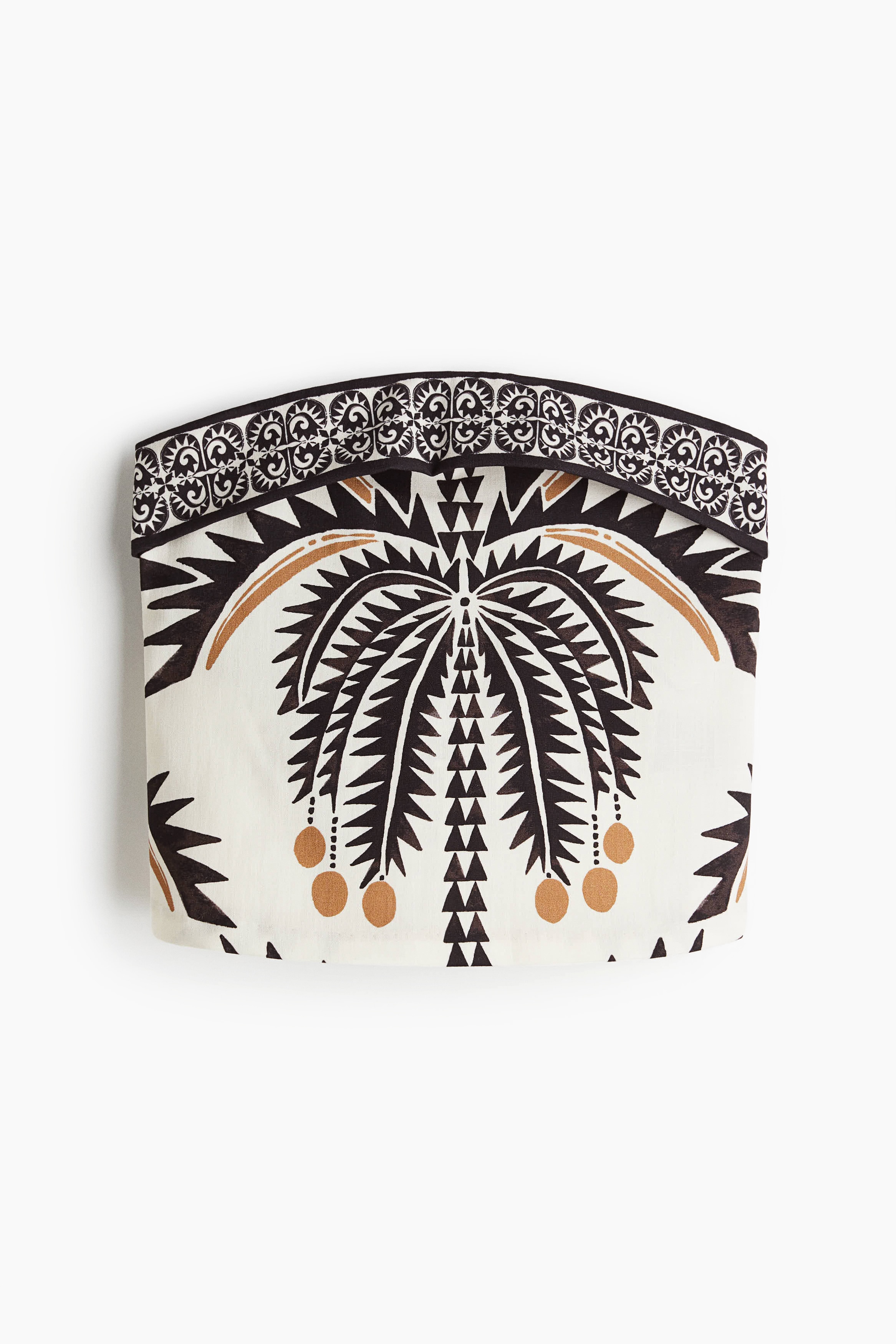 프린트 패턴 소재의 스트랩리스 크롭트 탑. 피트되는 실루엣. 상단을 접어 내린 스타일. 이미지