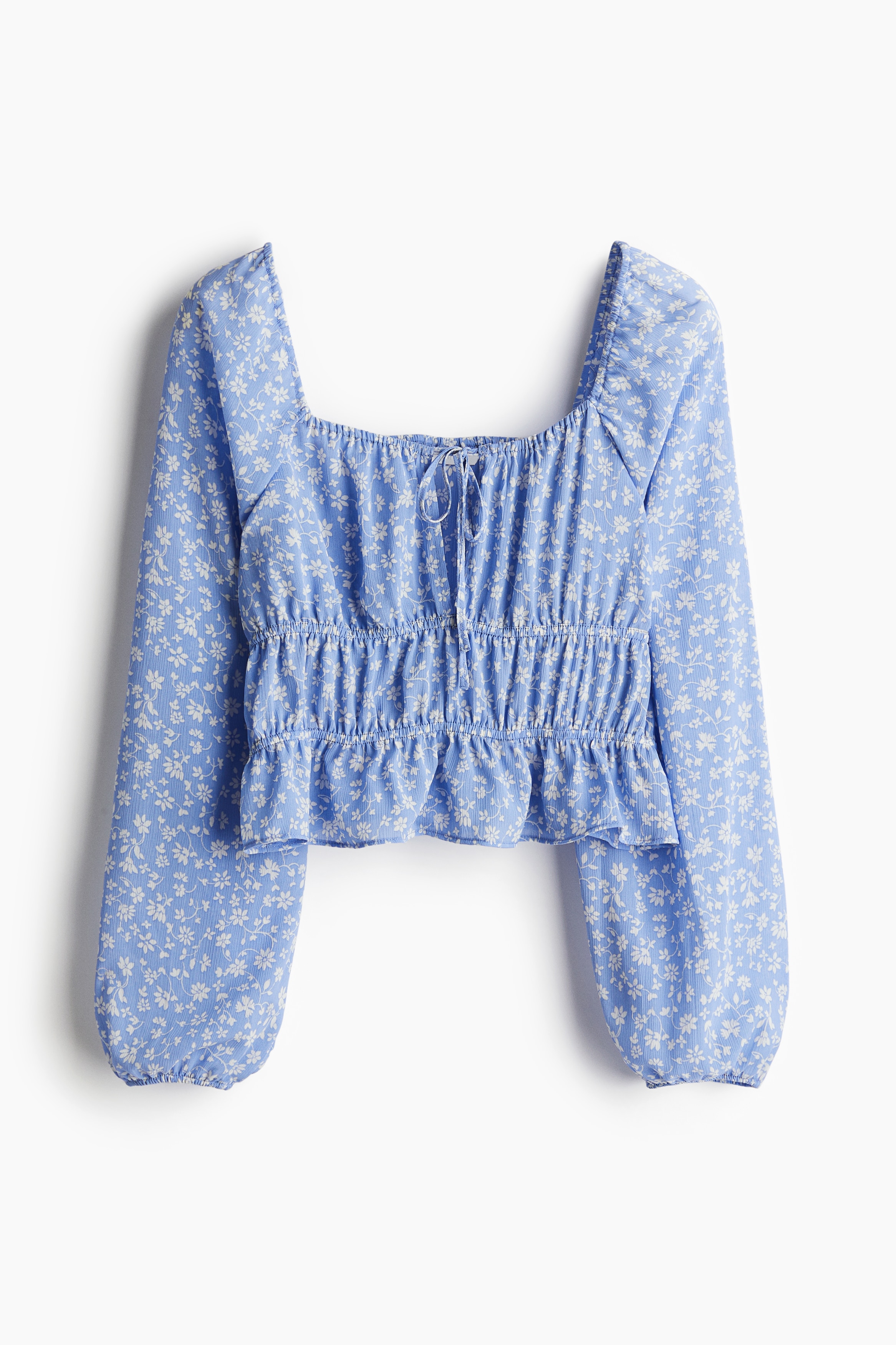 크링클 소재의 짧은 블라우스. 신축성 있는 스퀘어넥 앞면에 가느다란 드로스트링이 있음. 벌룬 스타일의 긴소매. 신축성 소맷단. 주름 효과를 주는 신축성 허리 솔기. 이미지