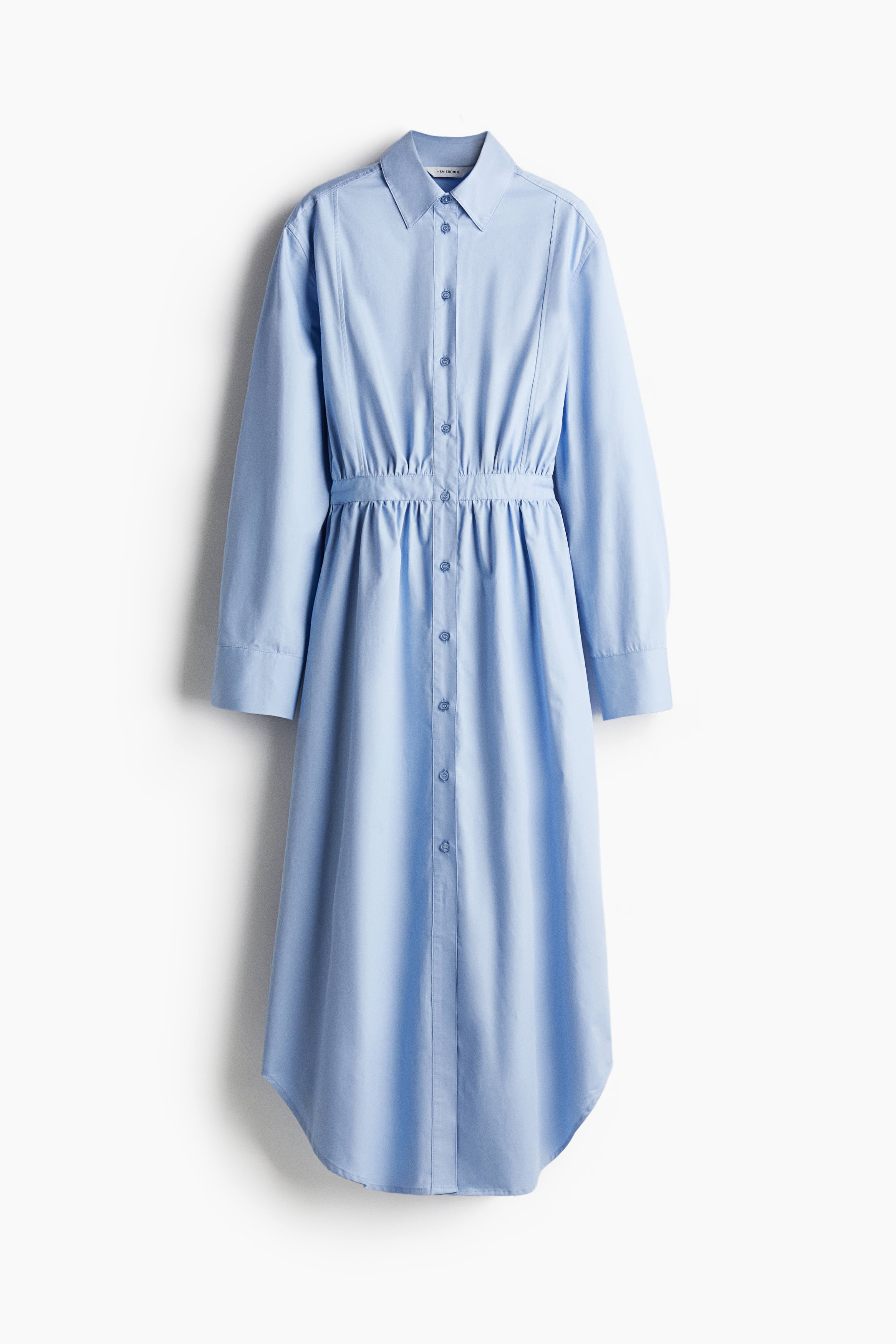 칼라가 있는 코튼 트윌 소재의 맥시 원피스. 빕 프런트 스타일. 앞면 버튼 클로저. 긴소매. 소맷단에 플래킷과 버튼이 있음. 피트되는 허리 부분에 주름이 잡힌 디자인. 라운드 헴라인. 안감 생략. 이미지