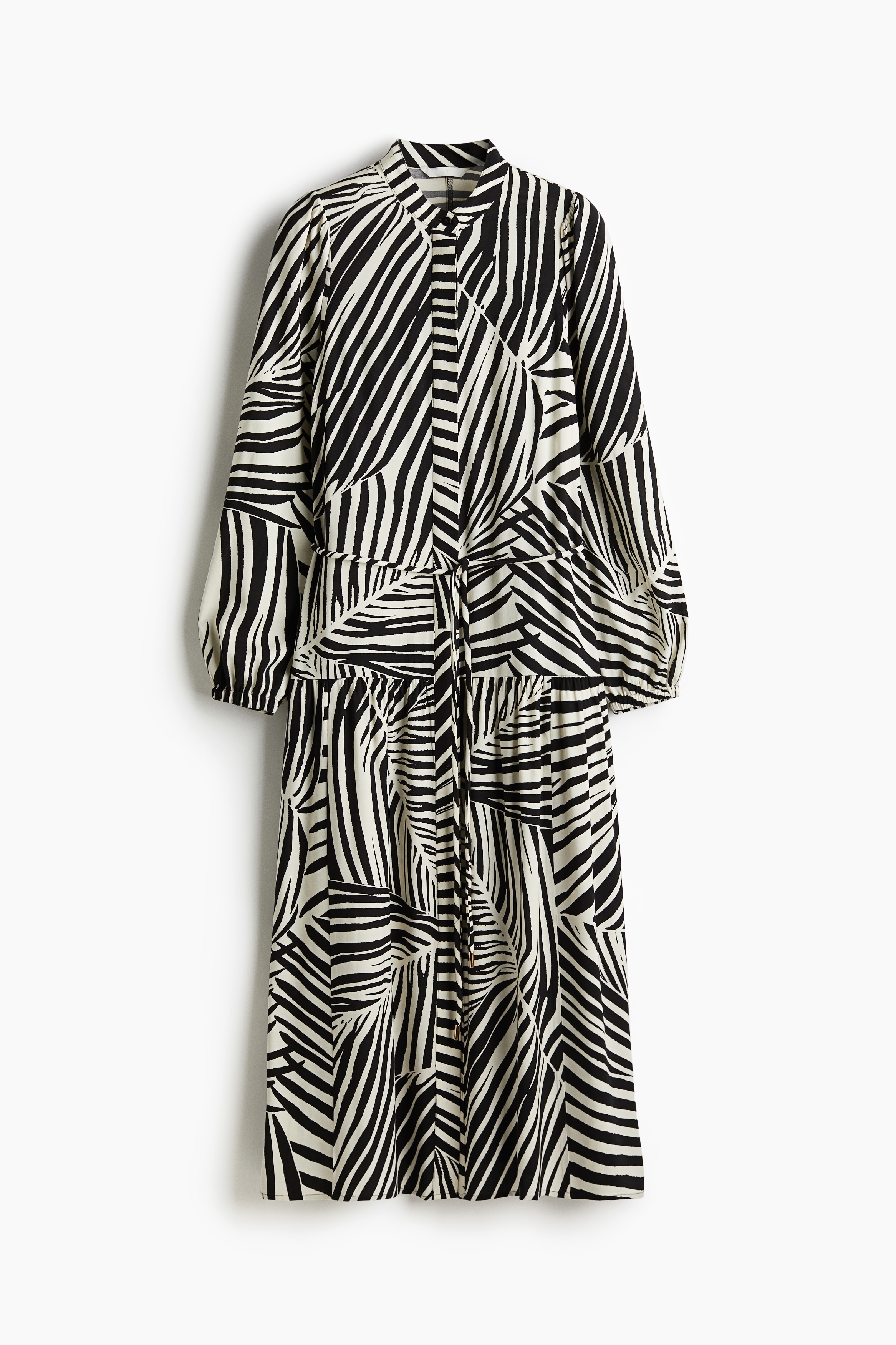 우븐 소재의 맥시 원피스. 밴드 칼라. 앞면 히든 버튼 클로징. 퍼프 스타일의 긴소매. 신축성 소맷단. 가는 탈부착식 끈 벨트 포함. 힙 아래 솔기에 주름을 잡아 풍성함을 더한 실루엣. 안감 생략. 이미지