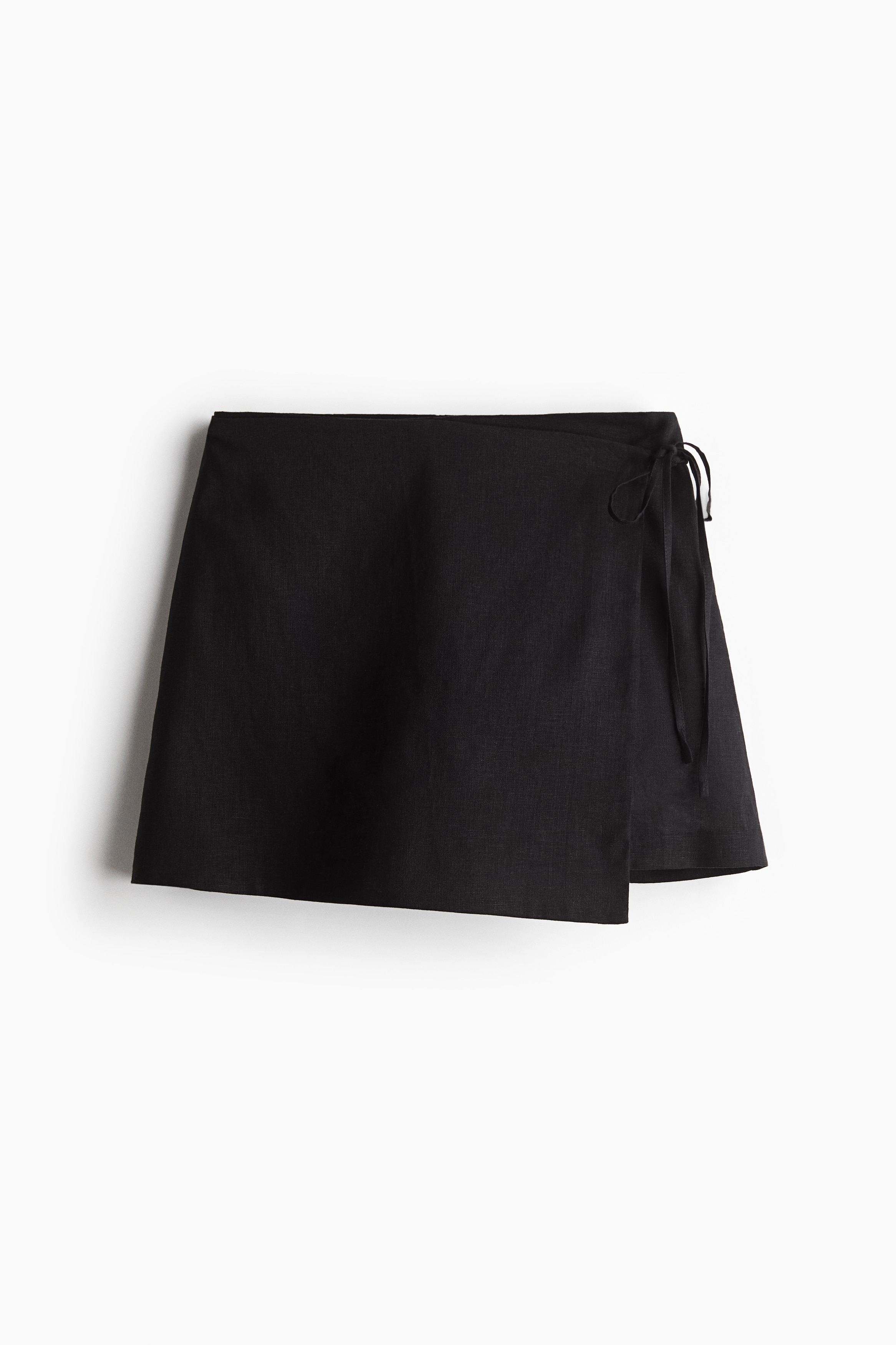 가벼운 리넨, 비스코스 혼방 소재의 짧은 스코트. 하이웨이스트. 랩스타일로 마감된 앞면에 끈이 있음. 한쪽 옆면 히든 지퍼와 후크 클로저. 이미지