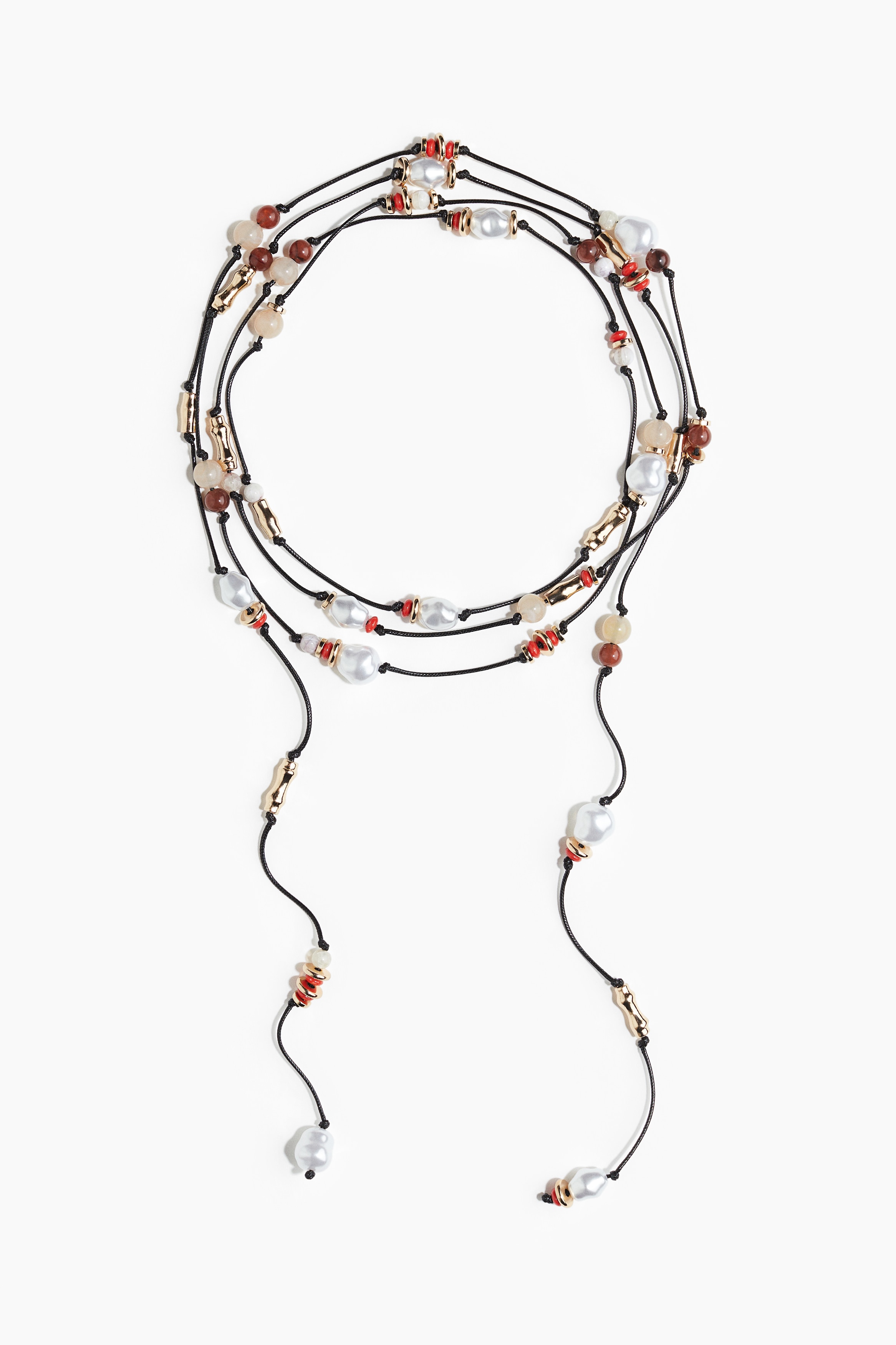 다양한 모양과 컬러의 플라스틱 비즈로 장식된 매듭진 긴 코드 목걸이. 이미지