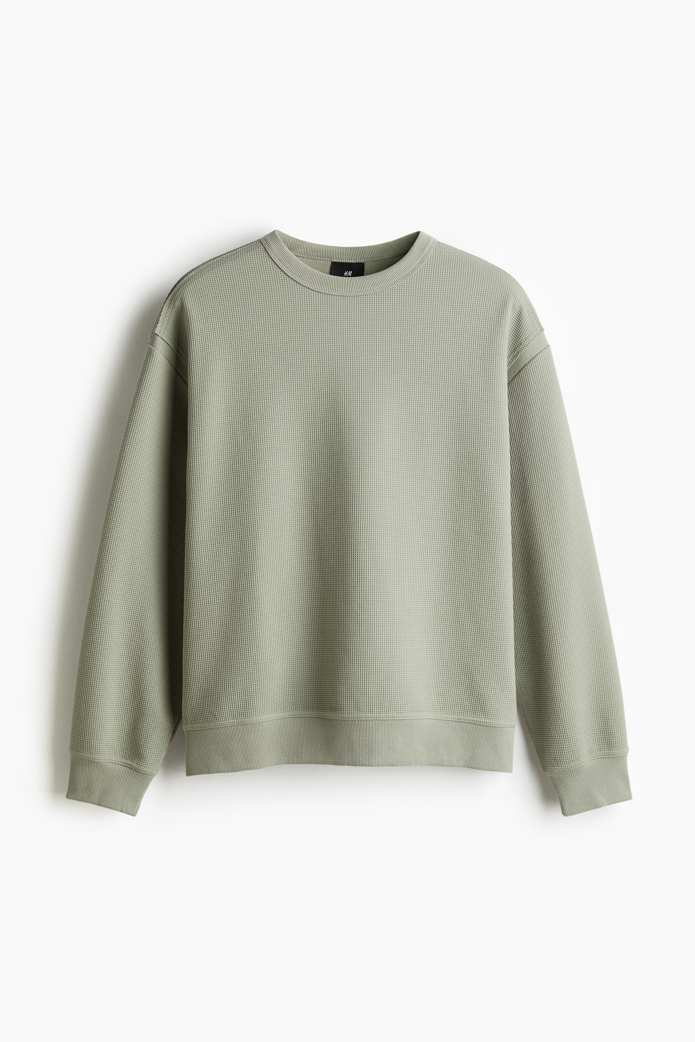 와플 텍스처가 있는 톡톡한 저지 소재의 긴소매 스웨트셔츠. 리브드 트리밍된 라운드넥. 드롭 숄더. 와이드한 리브드 마감 소맷단과 아랫단. 넉넉하지만 오버사이즈보다는 약간 피트되는 루즈핏 실루엣. 이미지