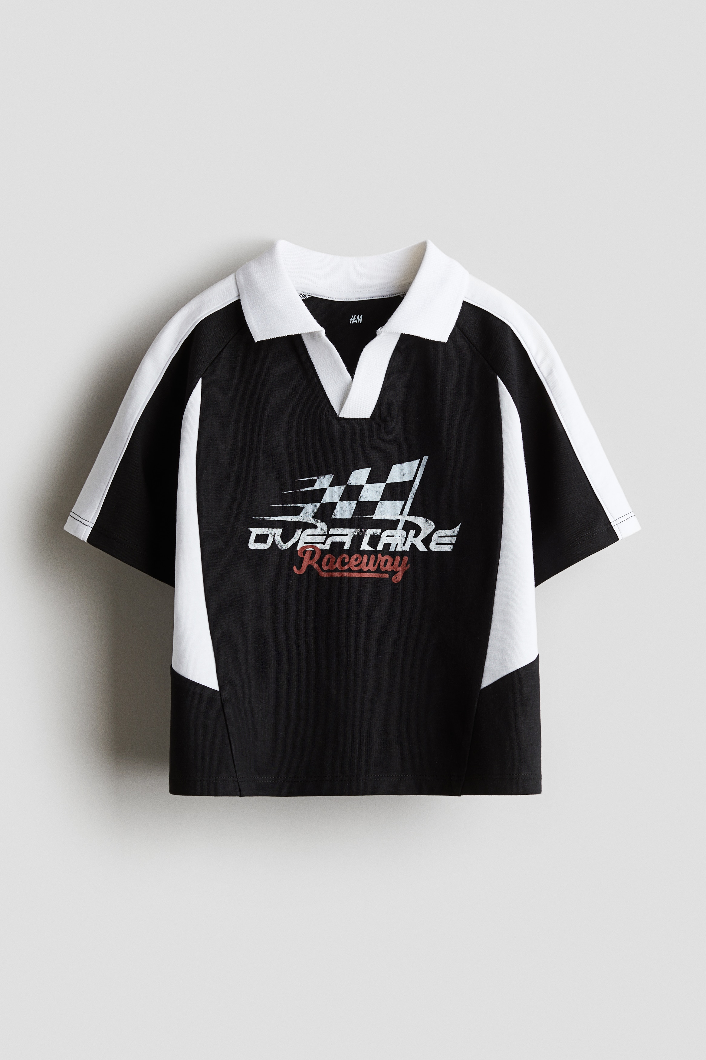 앞면에 프린트 장식이 있는 부드러운 코튼 저지 소재의 폴로셔츠. V자 트임이 있는 리브드 칼라. 래글런 스타일의 반소매. 이미지