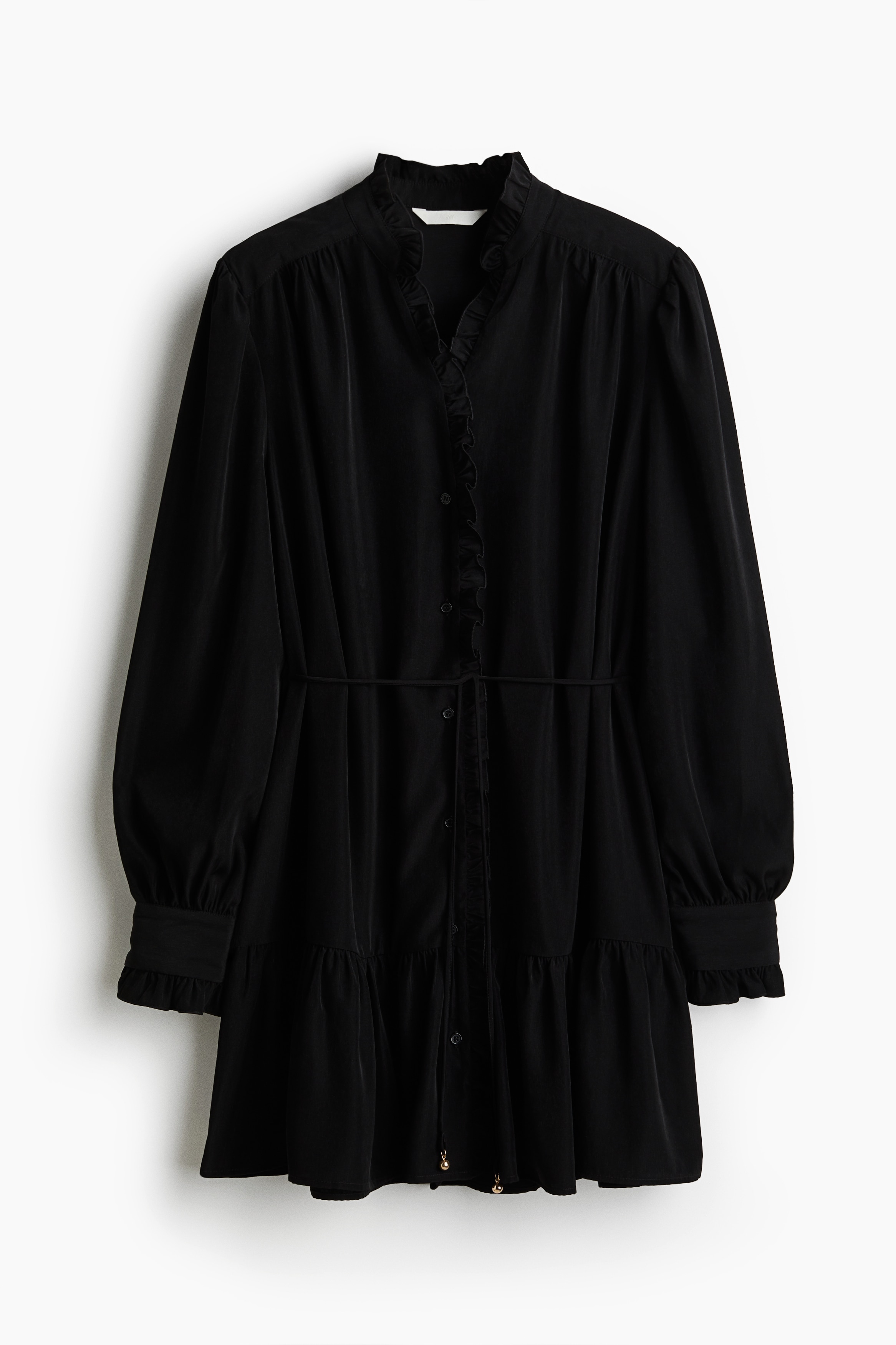 우븐 소재의 루즈핏 미니 드레스. 프릴 칼라. 프릴로 트리밍된 앞면 상단 버튼단. 어깨와 뒷면 요크 부분에 주름이 잡혀 있음. 긴소매. 프릴로 트리밍된 소맷단에 버튼이 있음. 가느다란 탈부착식 끈 벨트를 두른 디자인. 하단응ㄴ 주름이 잡힌 티어드 스타일로 마감됨. 안감 생략. 이미지