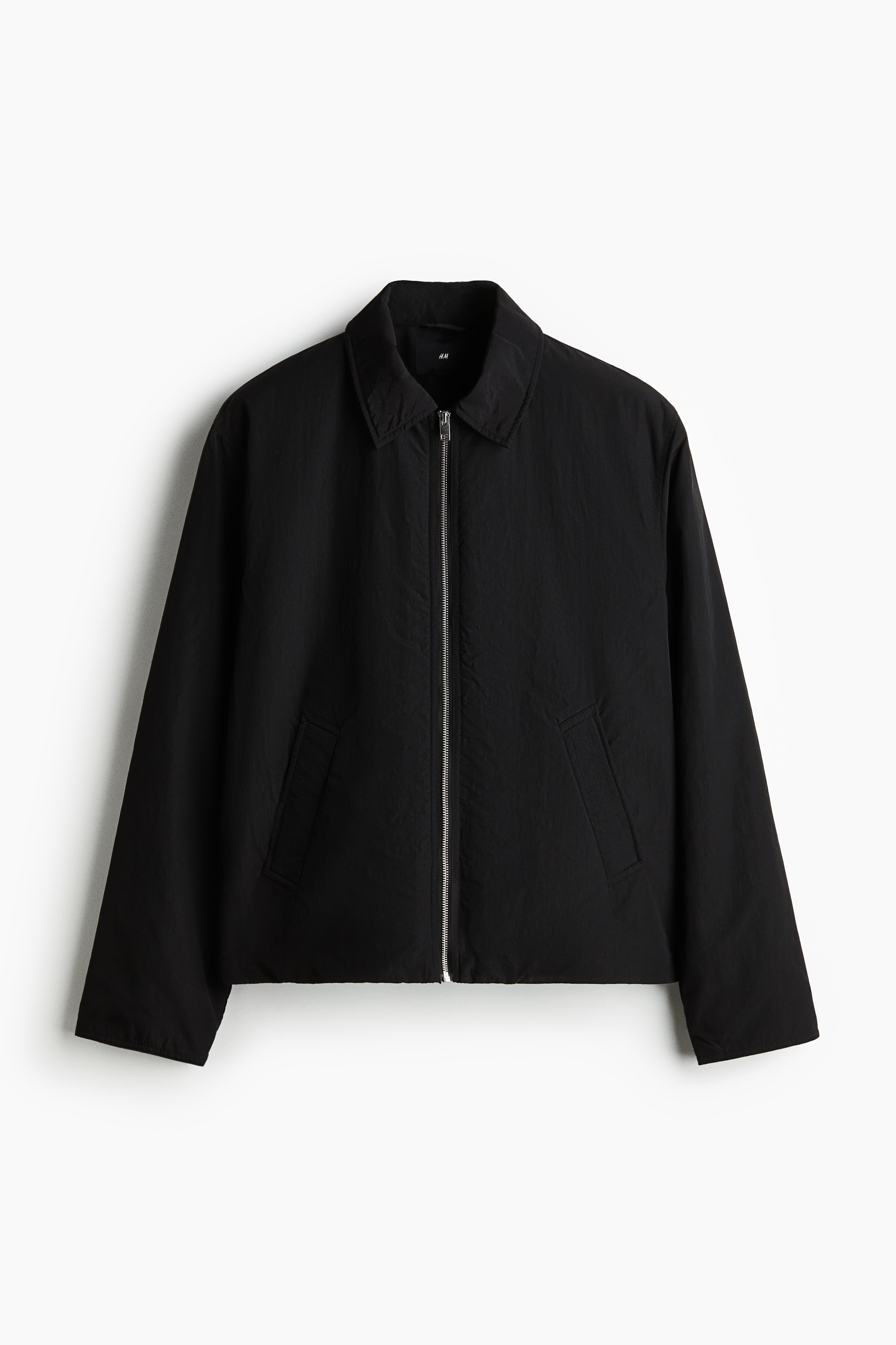 얇게 패딩된 빳빳한 나일론 소재의 재킷. 칼라와 앞면 지퍼가 있음. 사선 방향의 앞면 웰트포켓, 스냅버튼으로 여닫는 내부 포켓. 신축성 드로스트링과 코드락이 있는 아랫단. 착용감이 편안하고 클래식한 레귤러핏 실루엣. 안감 부착. 이미지