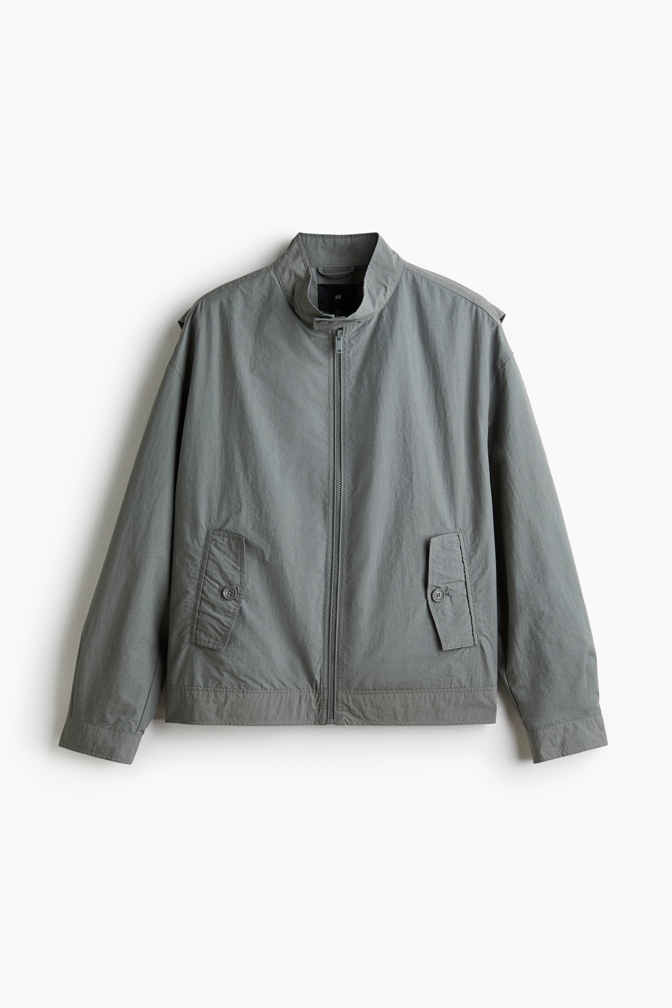 나일론과 코튼이 혼방된 재킷. 버튼이 있는 하이넥. 집업 스타일. 앞면 플랩포켓과 소맷단, 아랫단에 버튼이 있음. 넉넉하지만 오버사이즈보다는 약간 피트되는 루즈핏 실루엣. 안감 부착. 이미지
