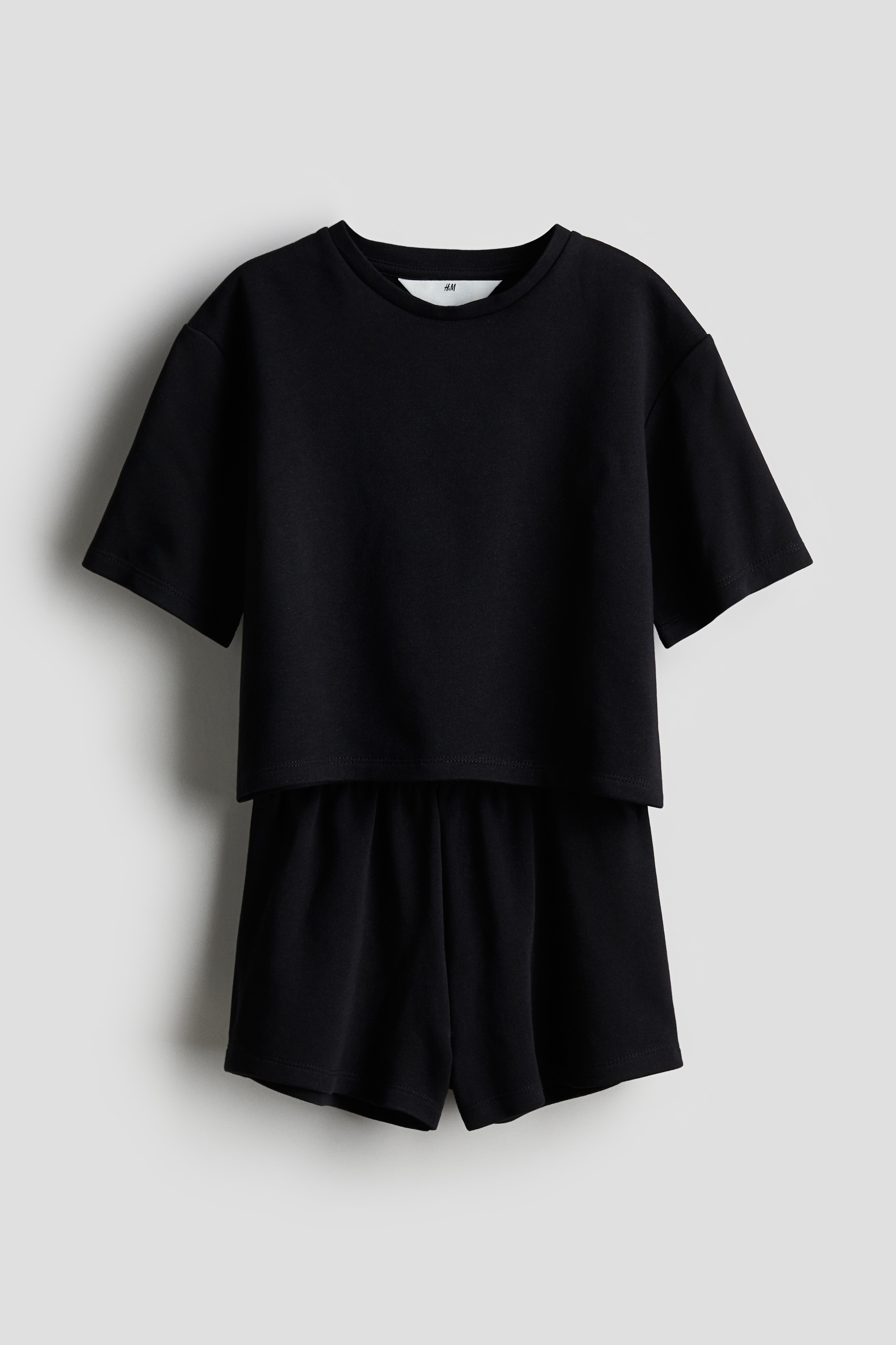 가벼운 스웨트셔츠 소재의 포근한 상하의 세트. 상의 - 드롭 숄더 스타일의 티셔츠. 리브드 라운드넥. 옆면에 짧은 트임이 있는 스트레이트 헴라인. 하의 - 허릿단에 밴딩이 내장된 반바지. 이미지