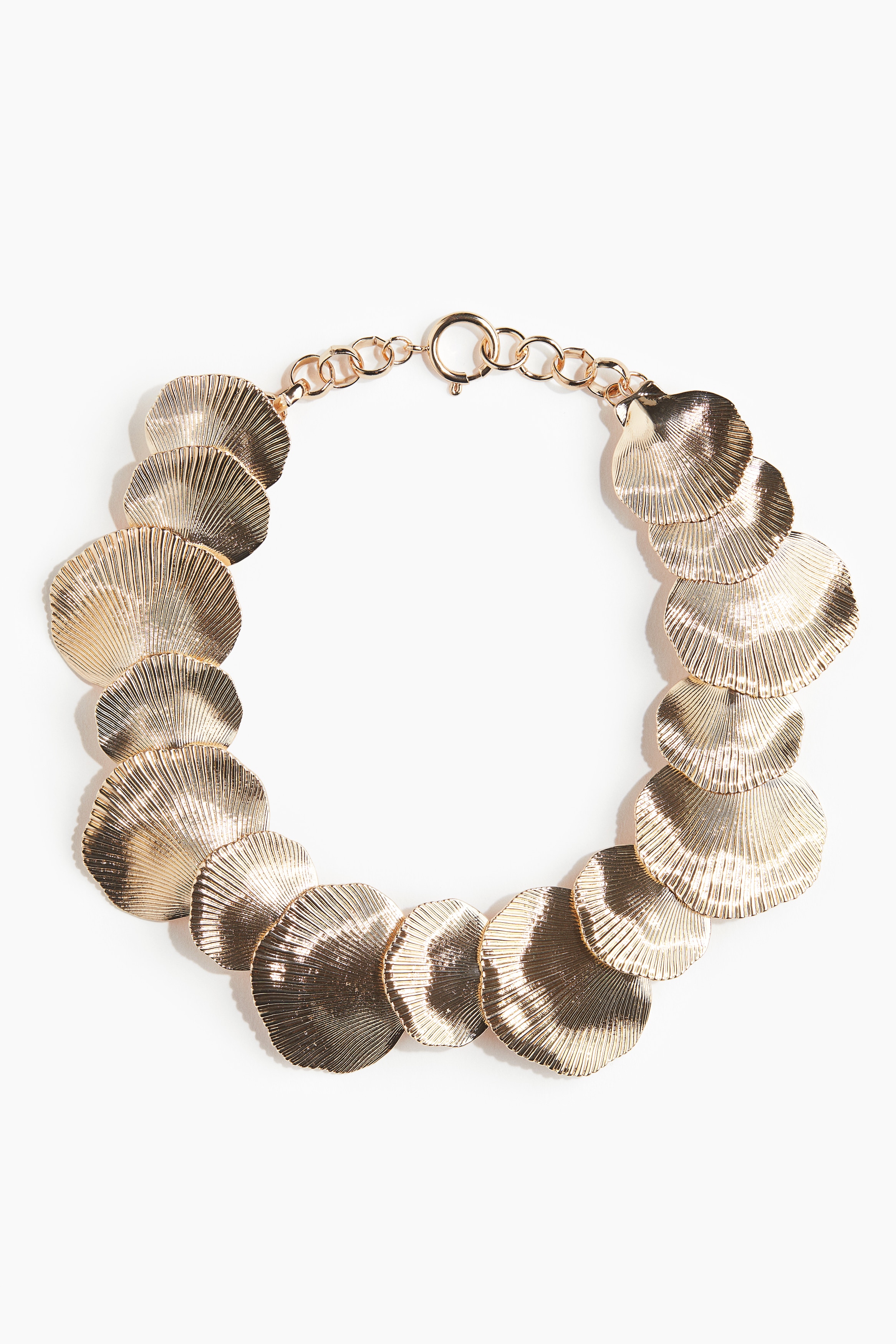 다양한 크기의 조가비 모양 디스크로 장식된 짧은 금속 목걸이. 스프링 고리 클로저로 사이즈 조절 가능. 이미지