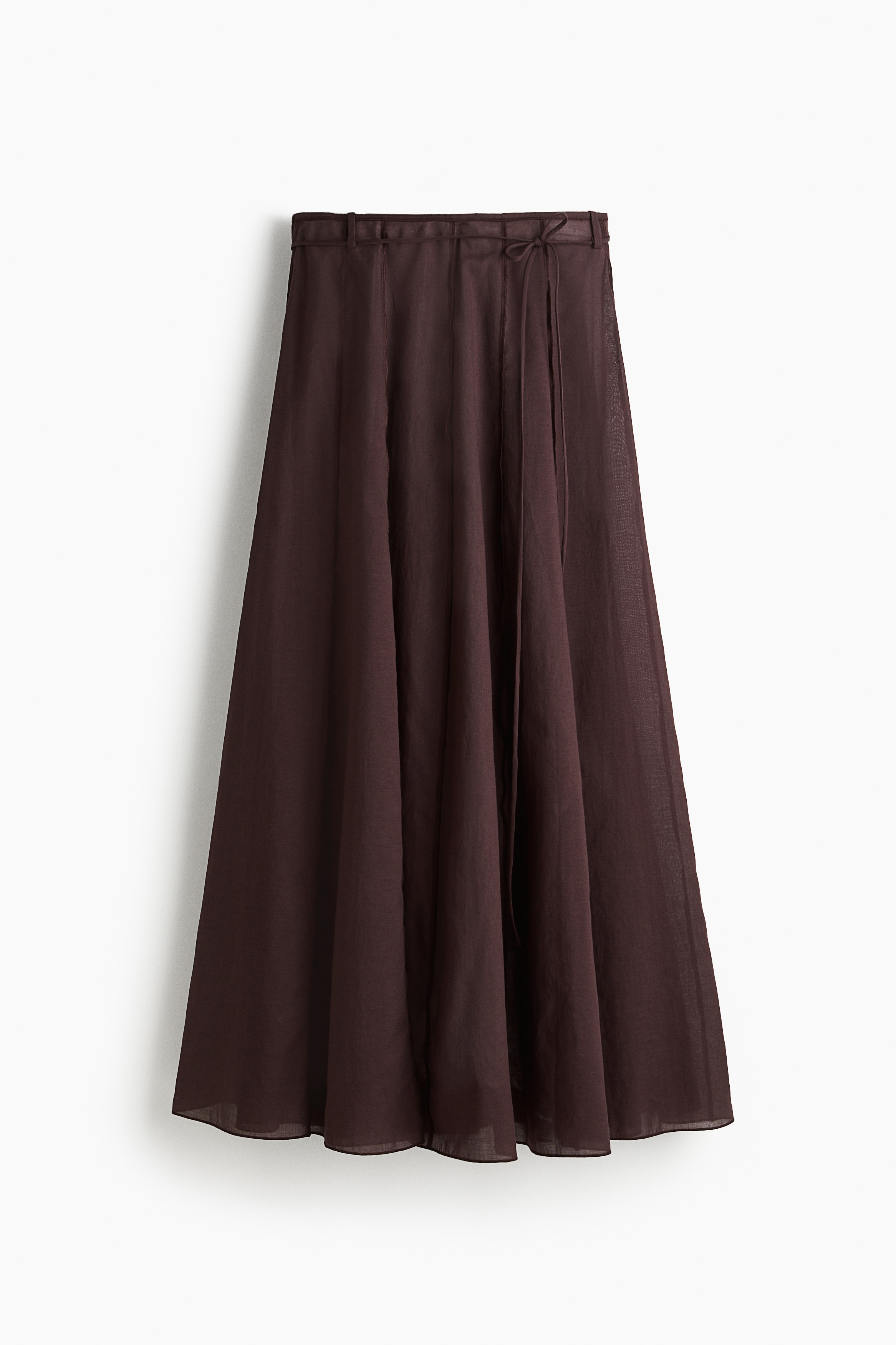 코튼과 리넨이 혼방된 가벼운 보일 소재의 맥시 스커트. 상단에서 하단으로 이어지는 솔기를 노출시켜 안팎이 뒤집힌 듯 연출한 스타일. 풍성한 플레어 실루엣. 하이웨이스트. 가늘게 바인딩처리된 허릿단. 한쪽 옆면 히든 지퍼와 후크 클로저. 옆면 히든 포켓. 가는 튜브 모양의 끈 벨트. 안감을 생략하여 가벼운 느낌을 주는 디자인. 이미지