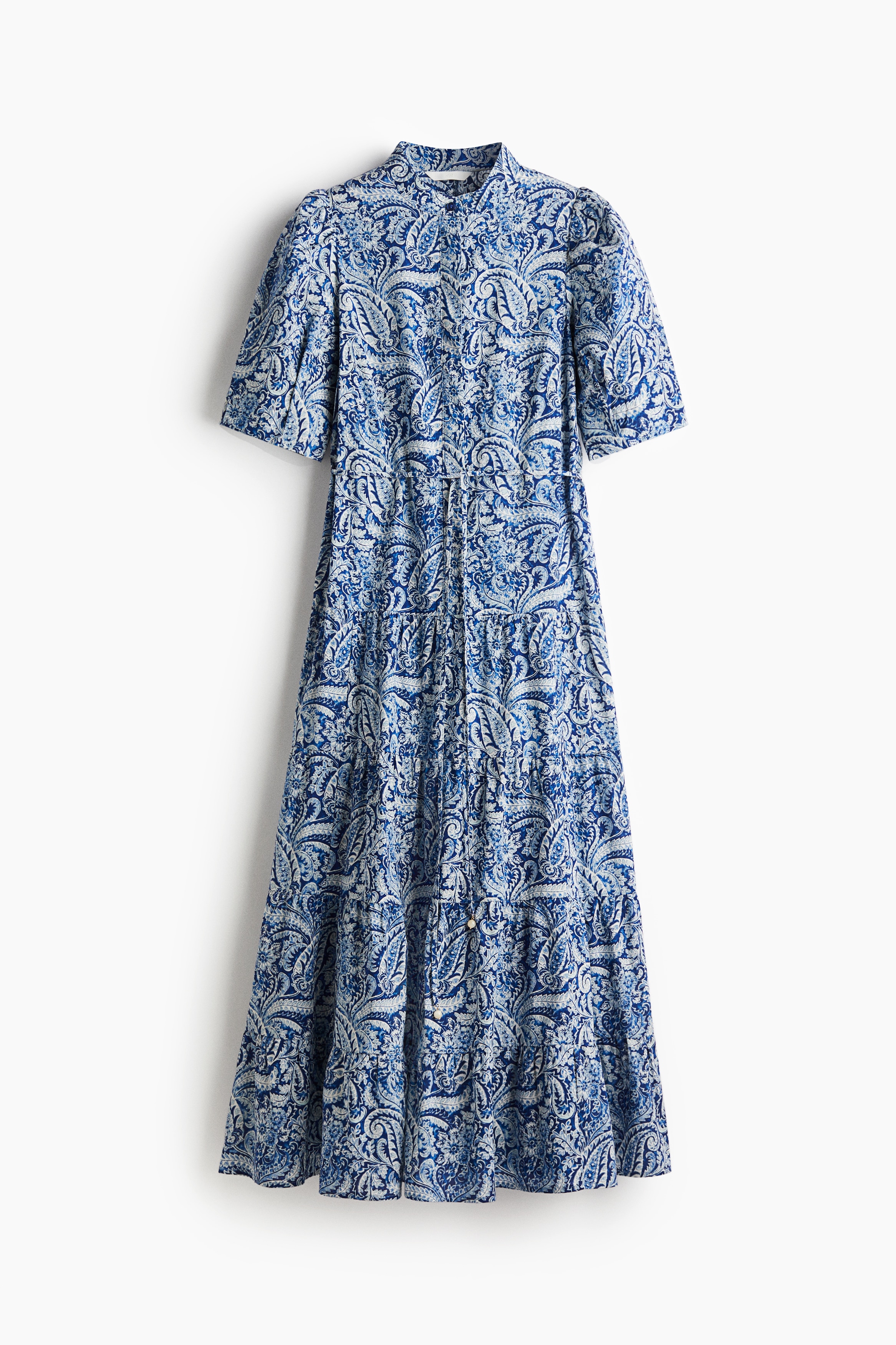 가벼운 코튼 소재의 맥시 원피스. 밴드 칼라. 상단 히든 버튼. 벌룬 스타일의 반소매. 가느다란 끈 벨트를 탈부착할 수 있음. 주름이 잡힌 티어드 스타일로 마감된 풍성한 플레어 라인의 하단. 안감 생략. 이미지