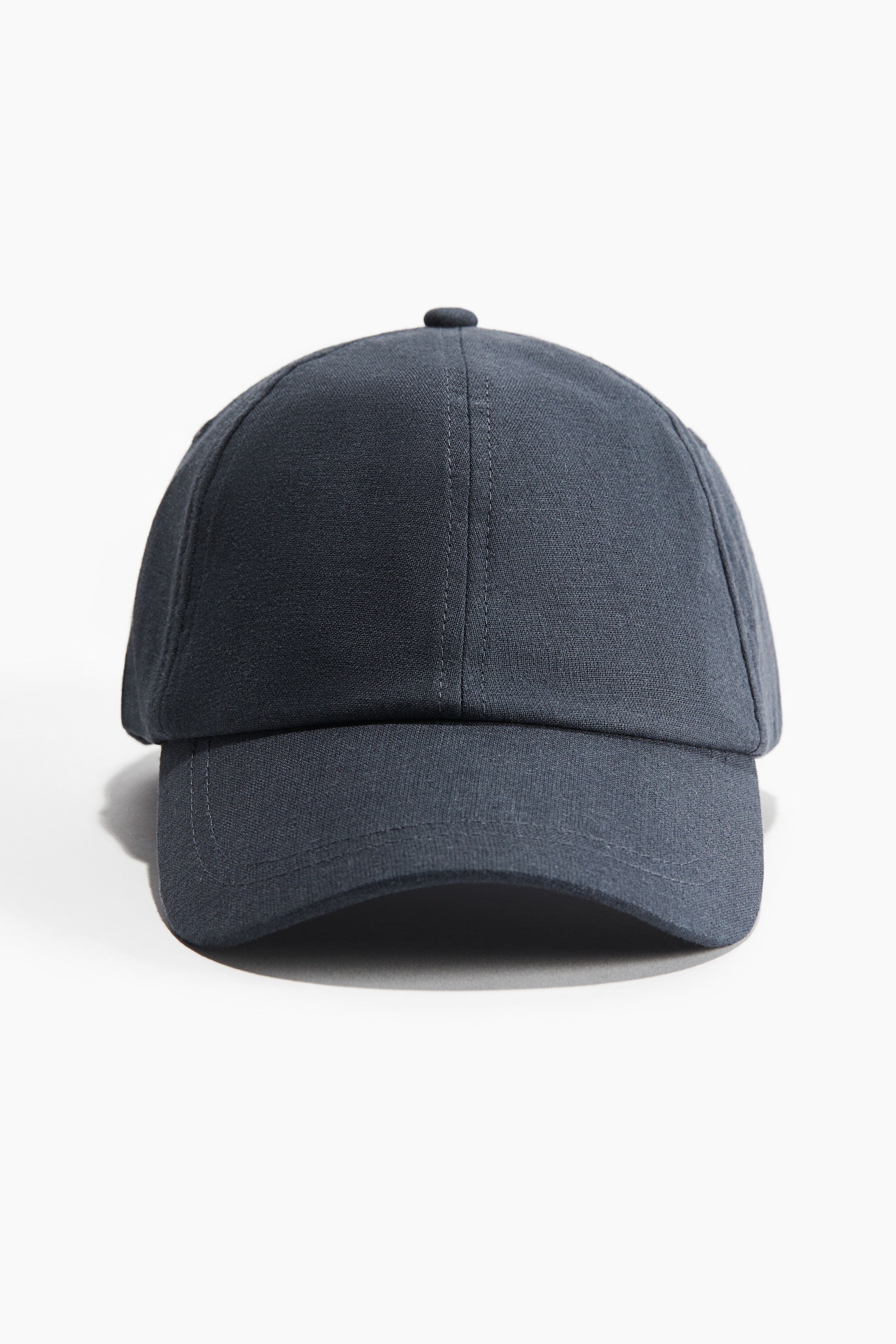 리넨과 코튼이 혼방된 가벼운 우븐 소재의 캡. 자수로 마감된 상단 아일릿. 뒷면 탭과 금속 버클로 핏을 조절하는 스타일. 코튼 스웨트밴드 내장. 이미지