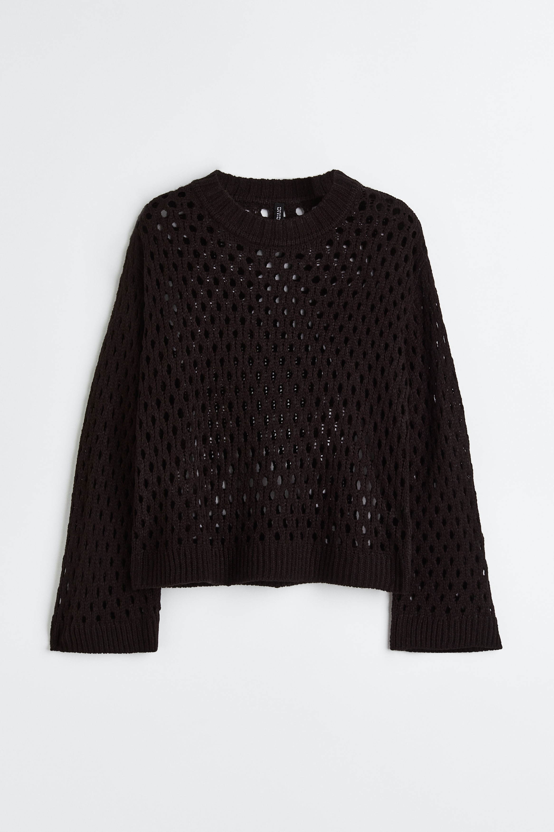 크로셰 느낌으로 연출한 부드러운 홀 니트 스웨터. 루즈핏. 골지로 단처리된 라운드넥. 드롭 숄더. 긴소매. 리브드 마감 소맷단과 아랫단. 이미지