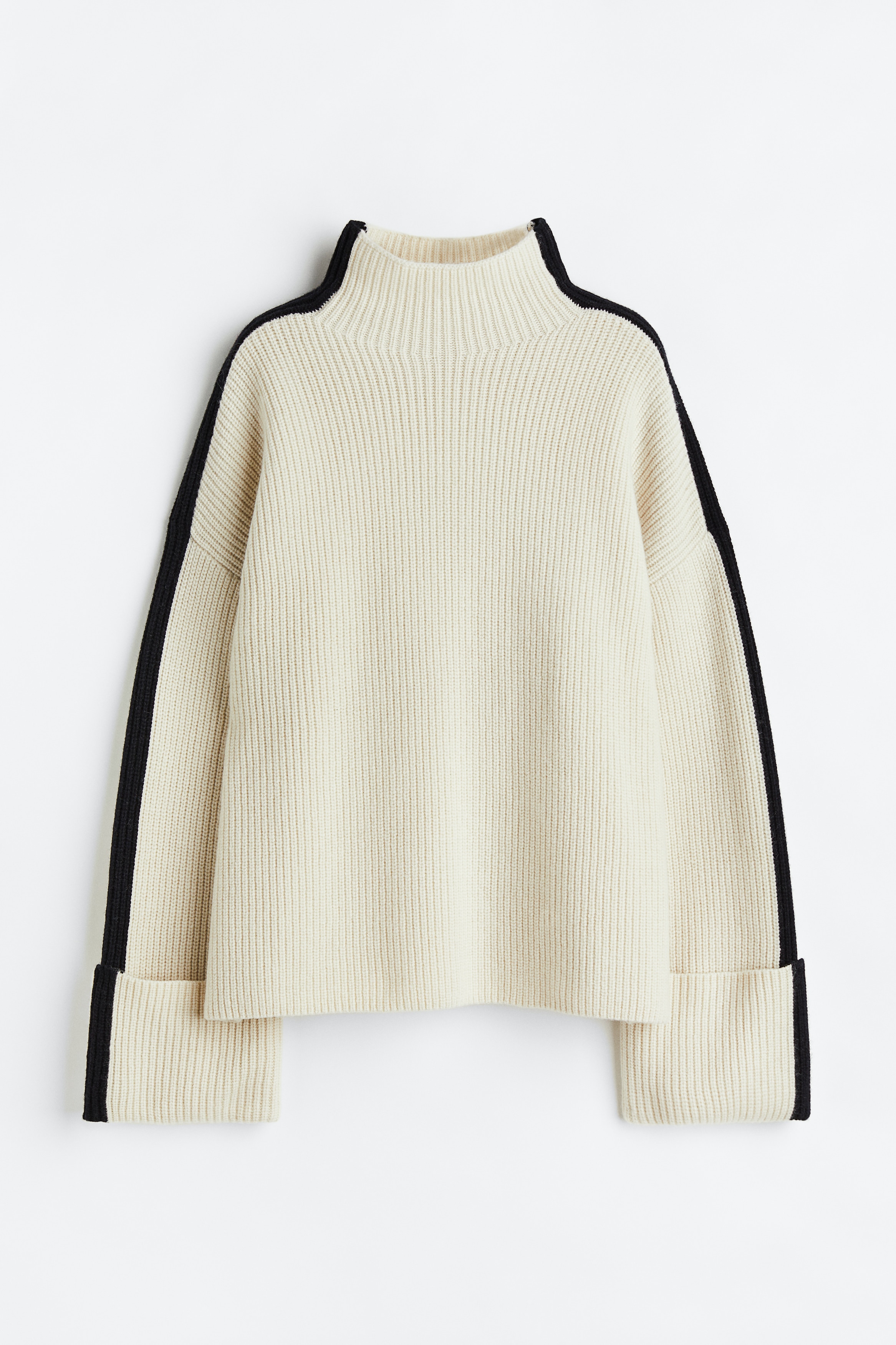 부드러운 울 소재의 오버사이즈 리브니트 스웨터. 터틀넥. 어깨 라인이 낮게 처리된 드롭 숄더. 폭이 넉넉한 긴소매. 접어 올린 와이드한 소맷단. 이미지