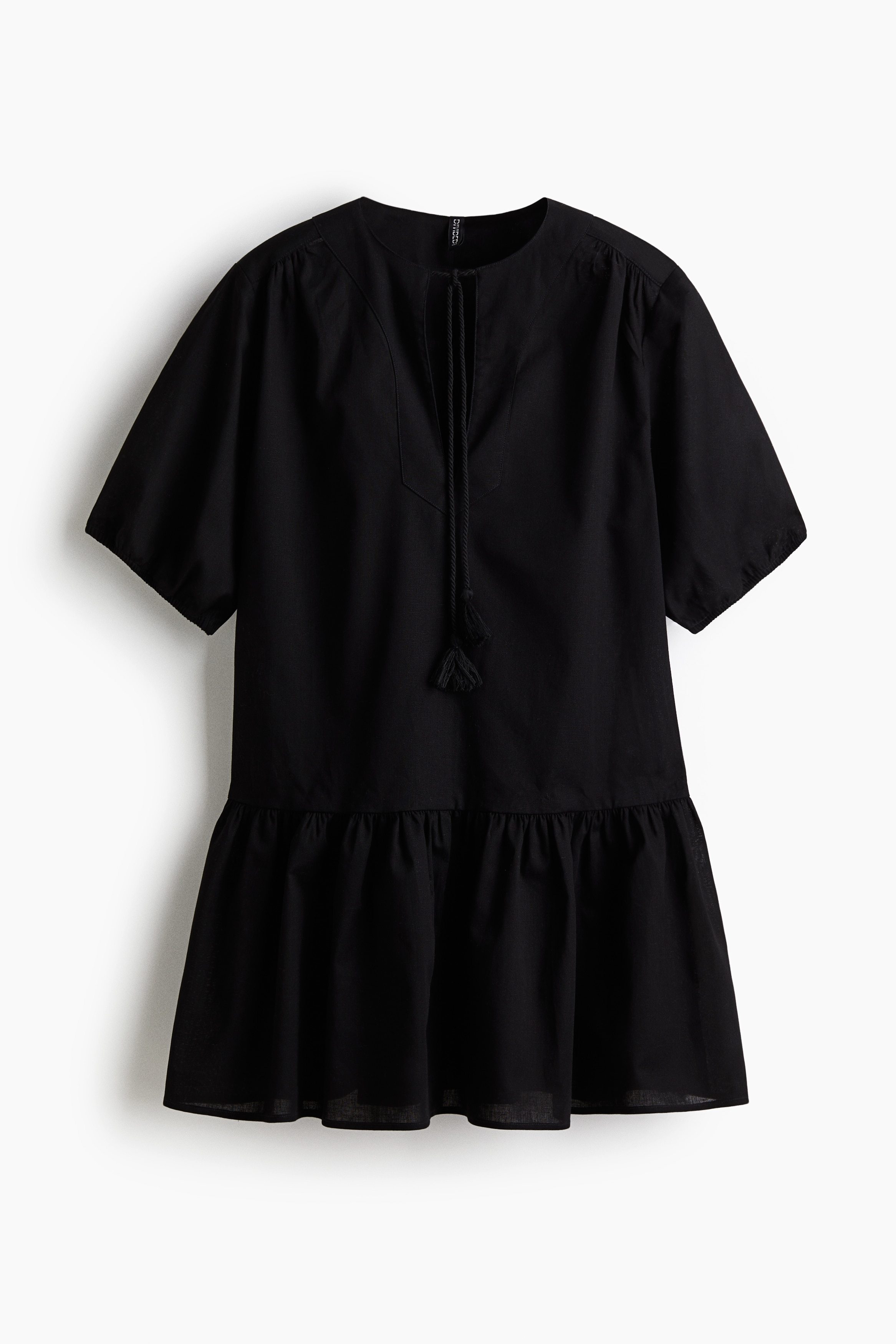 코튼이 혼방된 부드러운 데님 소재의 짧은 루즈핏 드레스. 깊은 V자 트임이 있는 라운드넥 앞면에 가느다란 끈이 있음. 앞면에 주름이 있으며 어깨 솔기가 앞면으로 치우친 디자인. 뒷면 요크. 퍼프 스타일의 5부 소매. 신축성 소맷단. 주름이 잡힌 힙 부분 솔기. 플레어 라인의 아랫단. 이미지