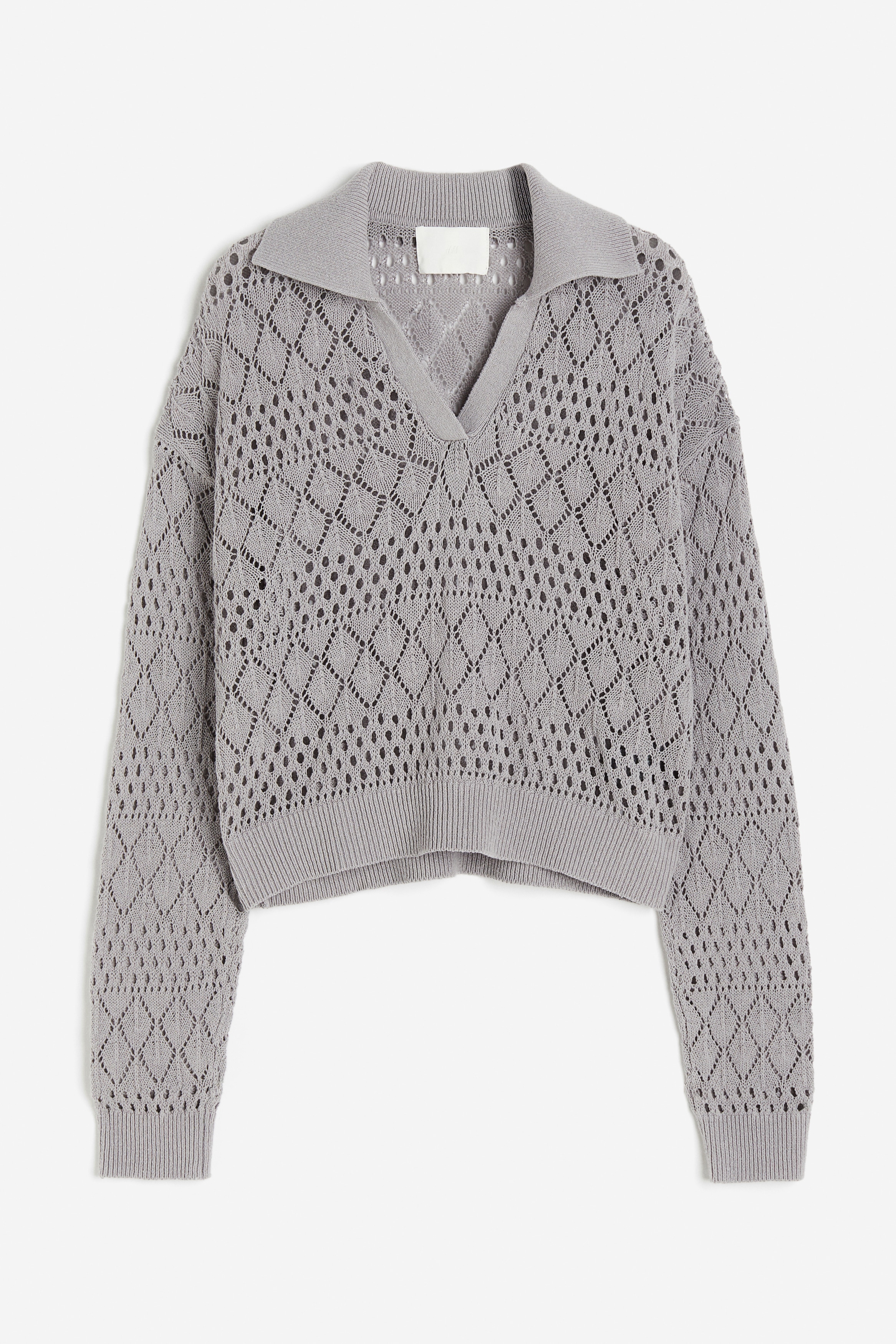 부드러운 포인텔 니트 소재의 짧은 스웨터. 리브드 칼라. 앞면 상단에 V자 트임이 있음. 드롭 숄더. 긴소매. 리브드 소맷단과 아랫단. 이미지