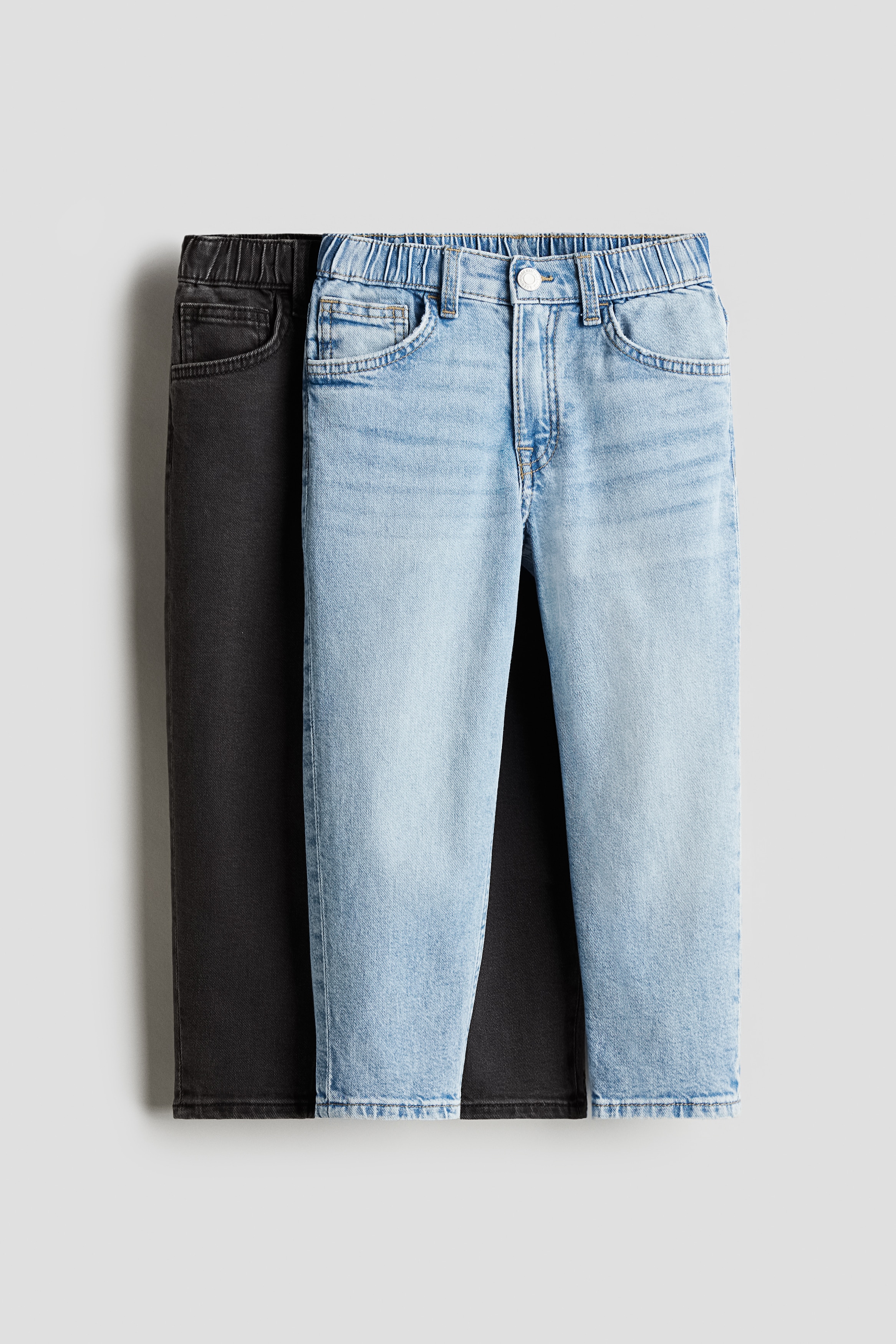 워싱처리된 코튼 데님 소재의 5포켓 진 세트. 밴딩으로 허리 사이즈 조절. 지퍼와 스냅버튼 클로저. 힙과 허벅지 부분이 루즈핏으로 처리됨. 테이퍼드 레그. 이미지