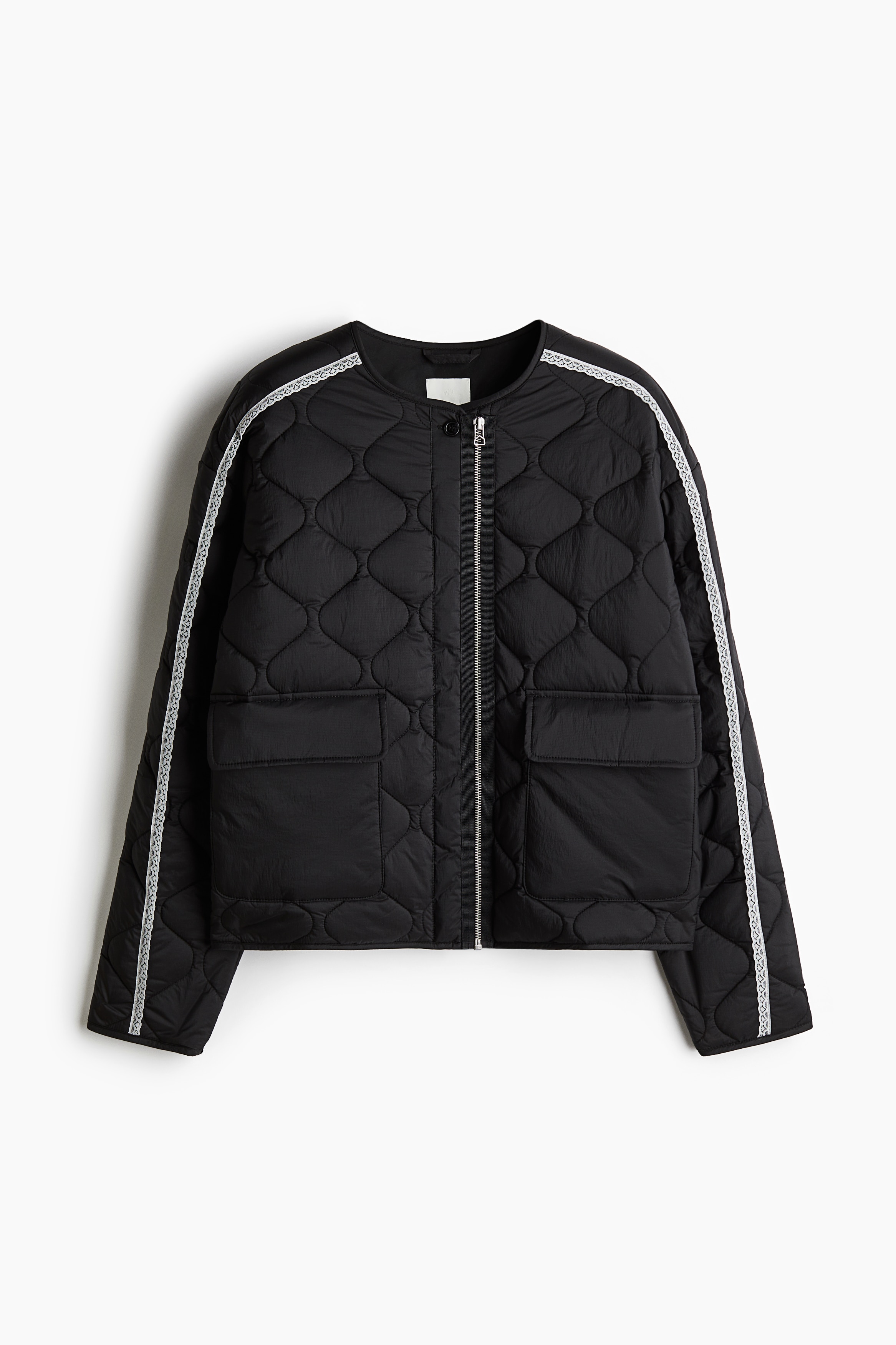 퀼팅처리된 나일론 소재의 얇은 패딩 재킷. 라운드넥. 앞면에 버튼 장식과 눈에 띄는 지퍼가 있음. 드롭 숄더. 대조적인 컬러의 레이스로 장식된 소매. 플랩이 있는 앞면 패치포켓. 가늘게 단처리된 옷단. 안감 부착. 이미지