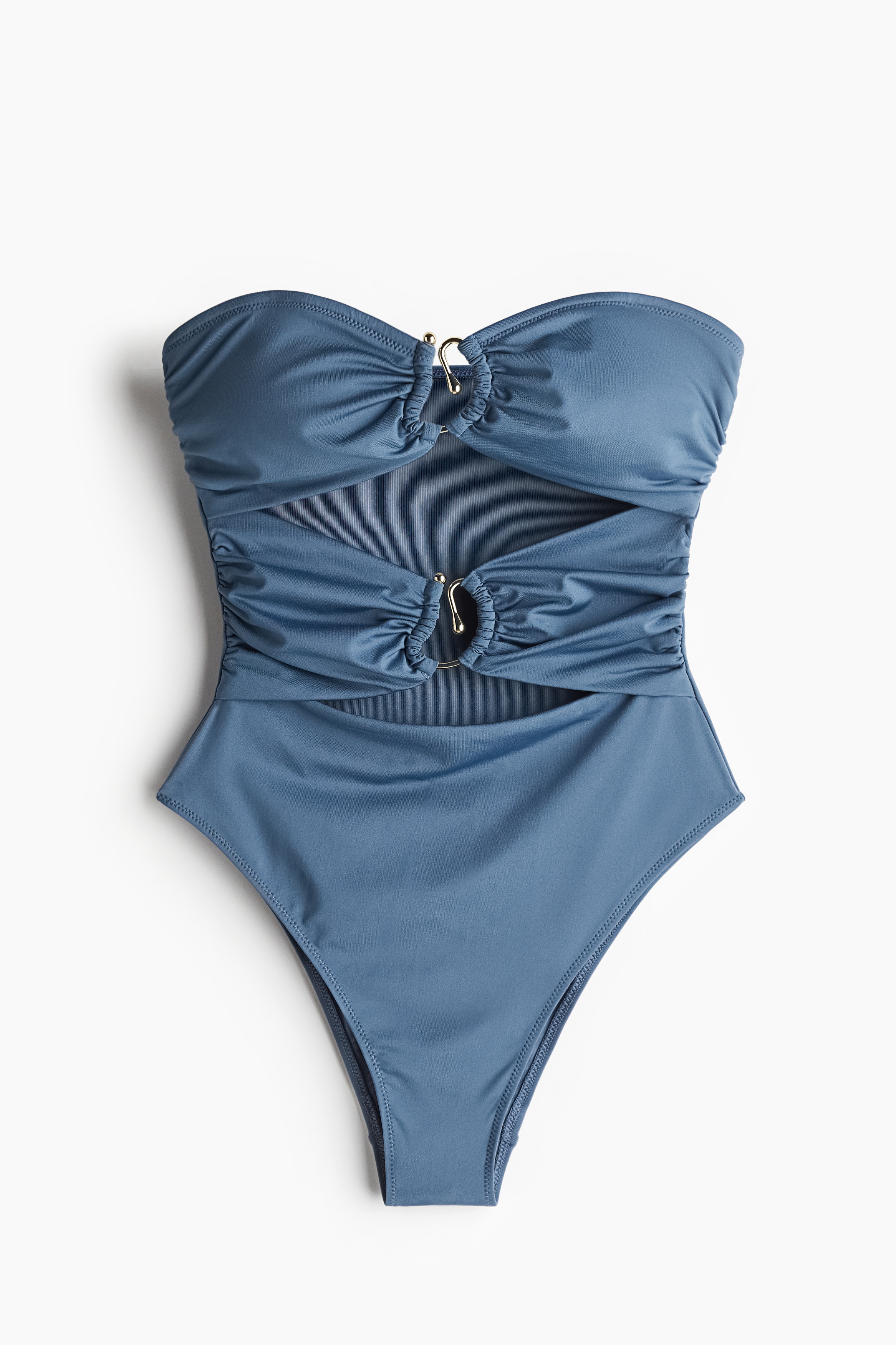 전체적으로 안감처리된 스트랩리스 수영복. 허리 앞면에 불규칙한 금속과 컷아웃 디테일이 있음. 컵에 탈부착식 캡이 내장되어 가슴 라인을 살려주며 탄탄하게 서포트해주는 디자인. 뒷면 하단이 기본형으로 커버되었으며, 다리 부분이 깊게 파인 하이컷 레그 스타일. 이미지