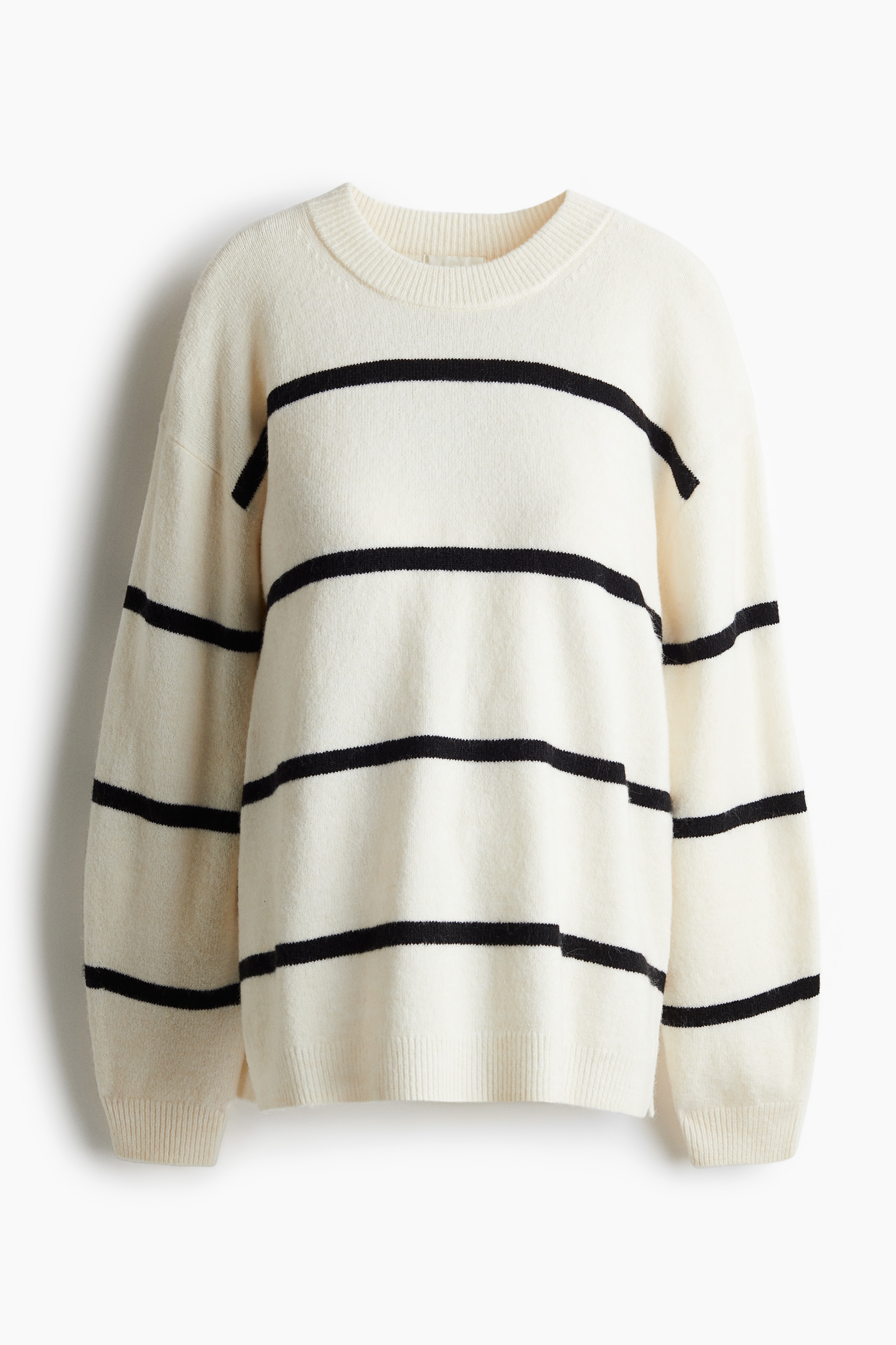 부드러운 니트 소재의 긴소매 라운드넥 스웨터. 드롭 숄더. 옆면 하단에 트임이 있는 스트레이트 헴라인. 리브드 마감된 옷단. 이미지