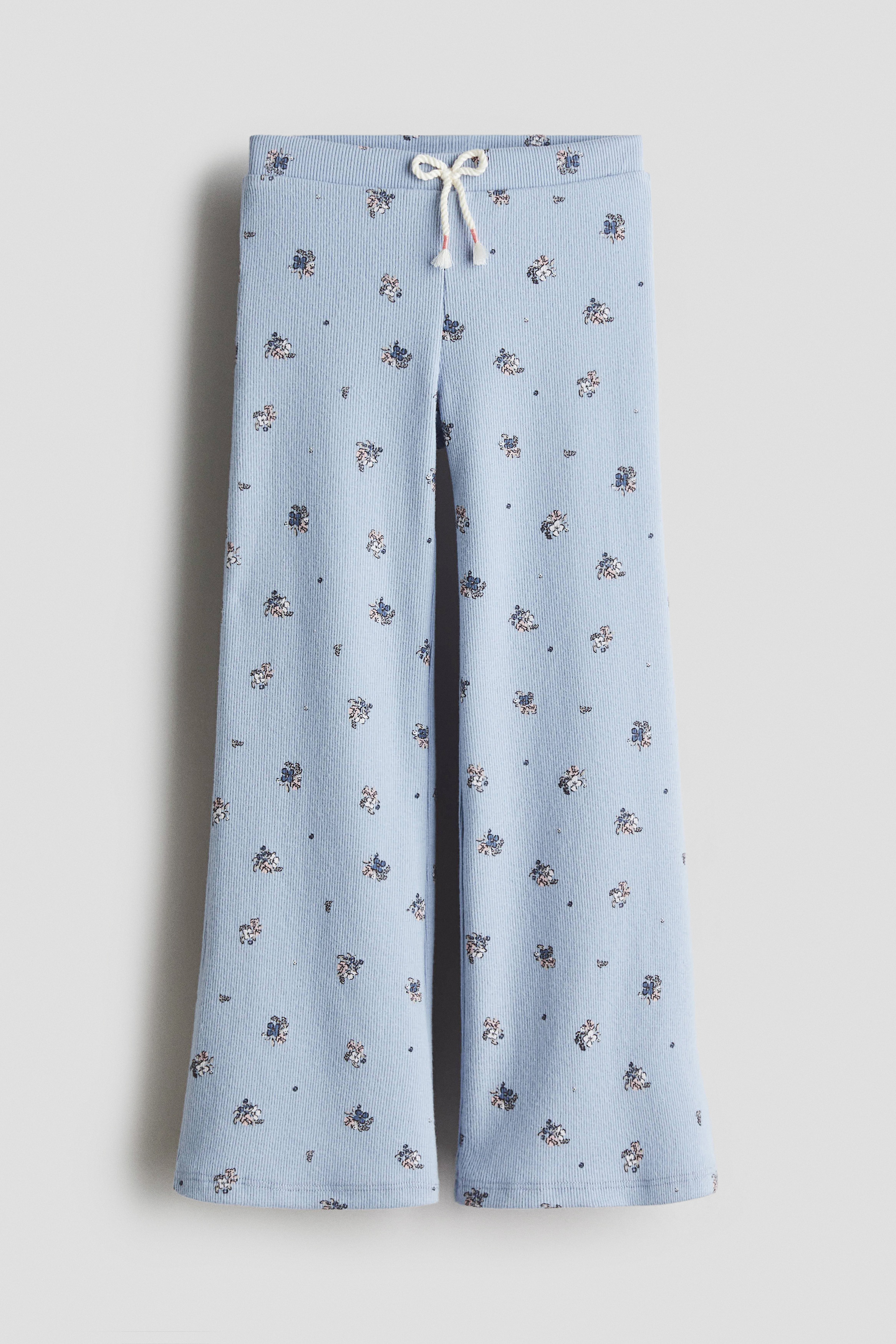 프린트 패턴이 있는 부드러운 리브드 저지 소재의 레깅스. 앞면에 끈 디테일이 있는 신축성 허릿단. 세미 플레어 레그. 이미지