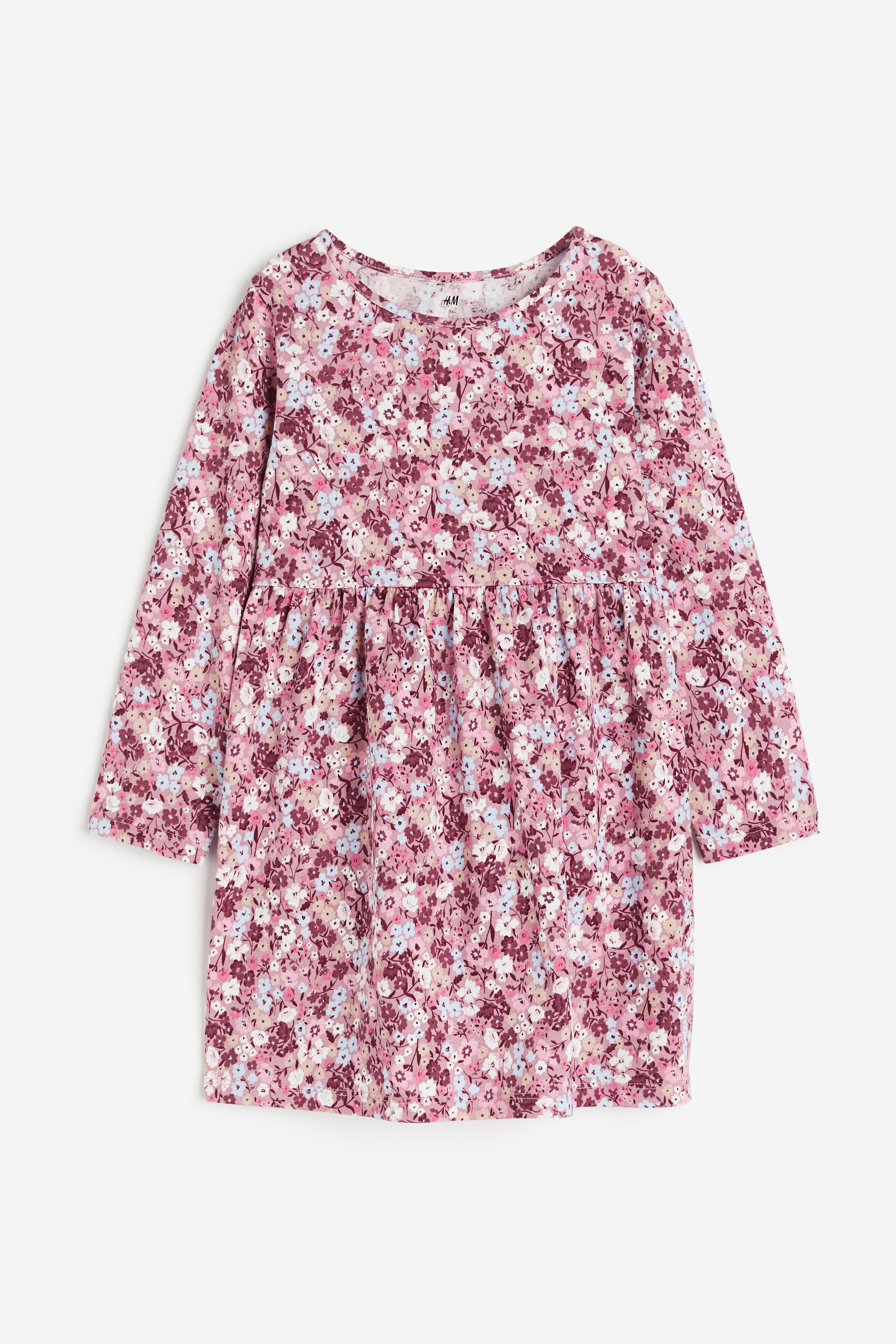 패턴이 있는 부드러운 코튼 저지 소재의 긴소매 원피스. 라운드넥. 주름이 잡힌 허리 솔기 아래는 풍성한 플레어 라인으로 처리됨. 이미지