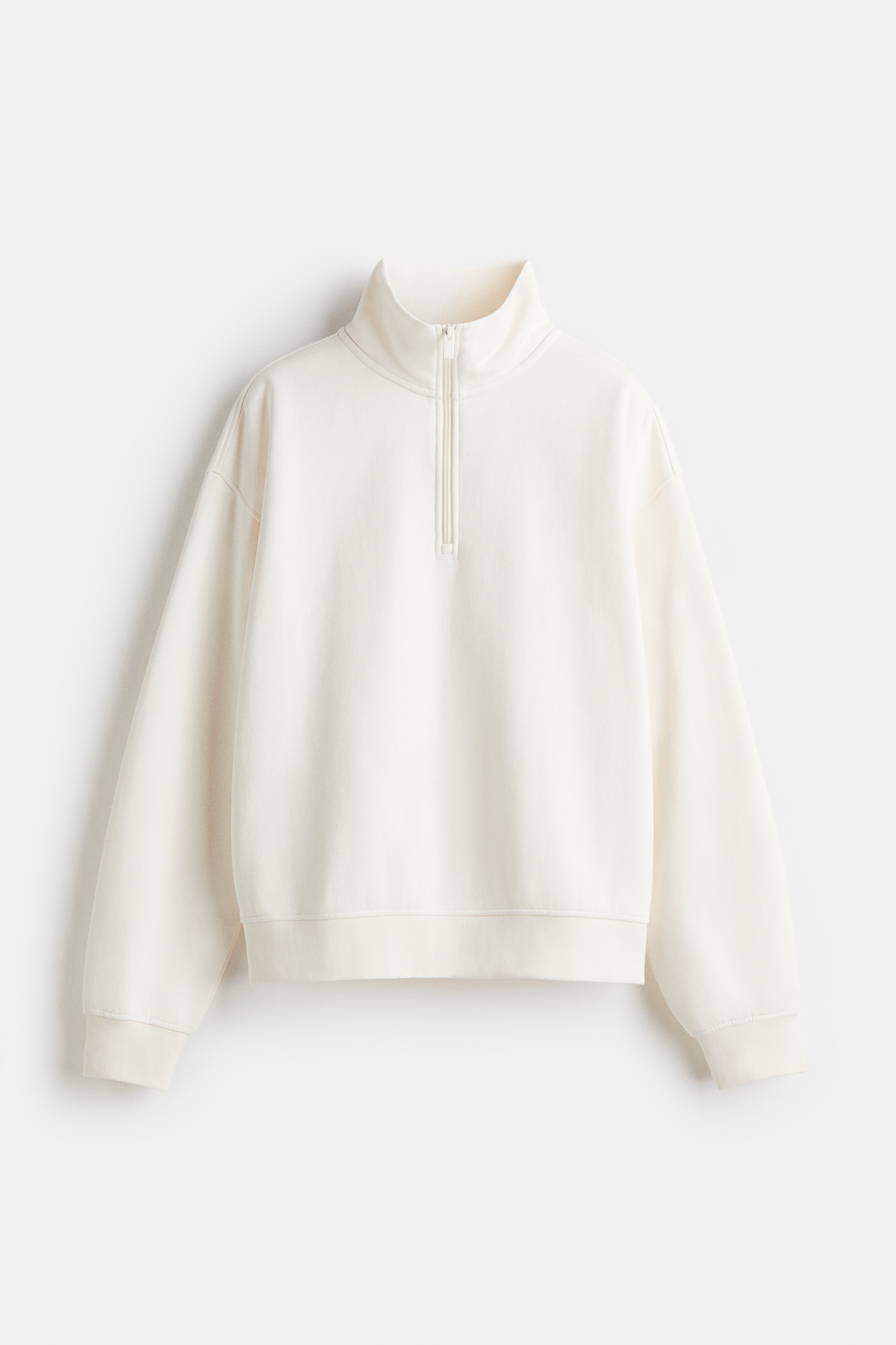 내부가 부드럽게 기모처리된 오버사이즈 스웨트셔츠. 하이넥. 상단 지퍼. 드롭 숄더. 긴소매. 리브드 소맷단과 아랫단. 이미지