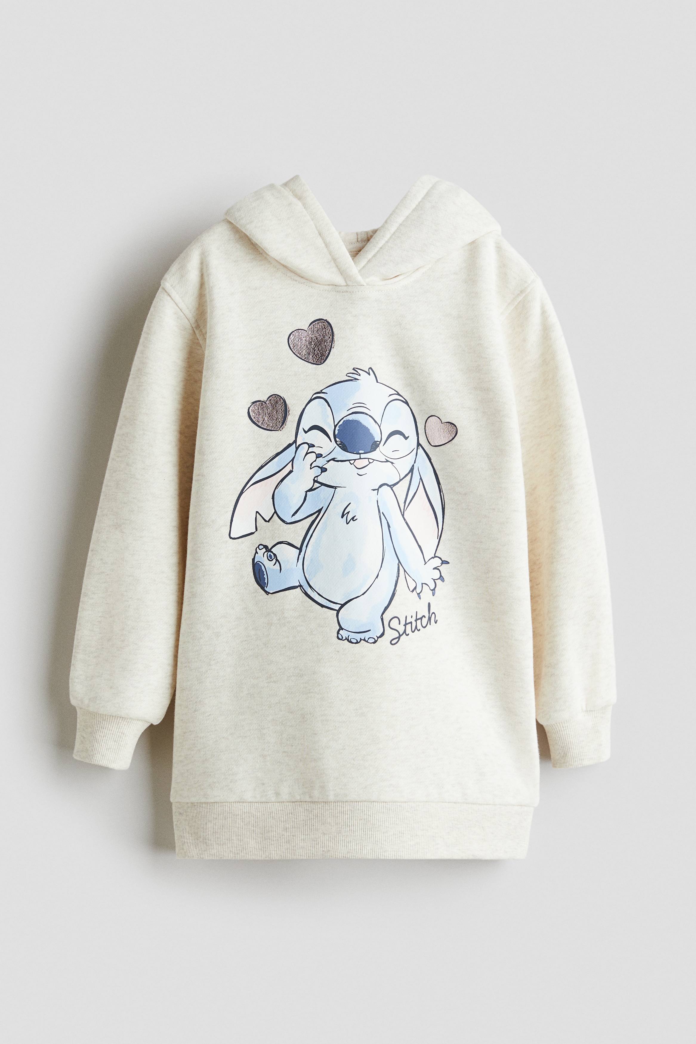 내부가 부드럽게 기모처리된 루즈핏 드레스. 앞면에 프린트 장식이 있음. 저지로 안감처리된 랩스타일 후드. 드롭 숄더. 긴소매. 골지 소맷단과 아랫단. 이미지