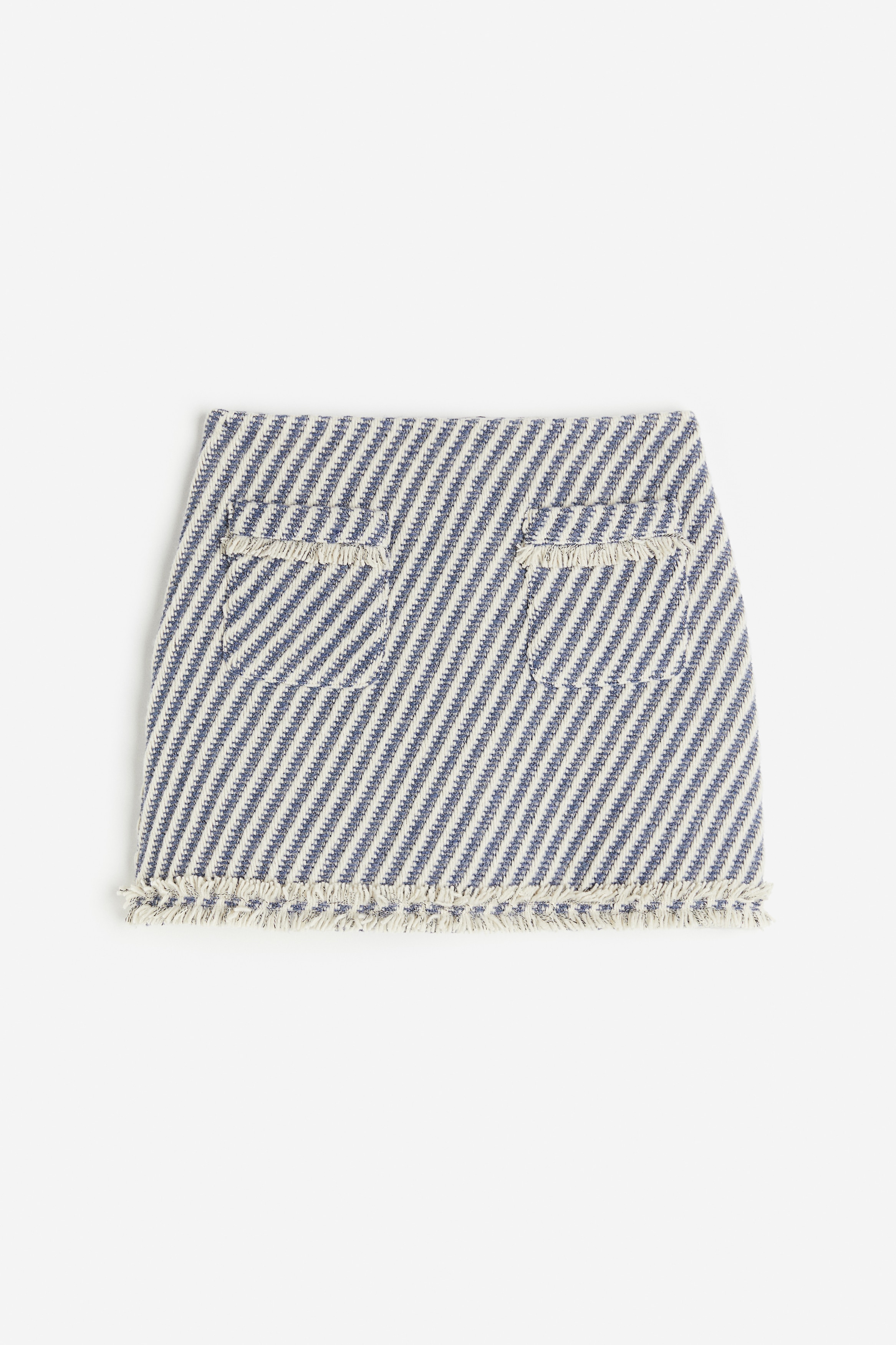 텍스처가 있는 우븐 소재의 A라인 미니 스커트. 프린지 트리밍. 앞면 패치포켓. 허리 뒷면 히든 지퍼 클로징. 안감 부착. 이미지