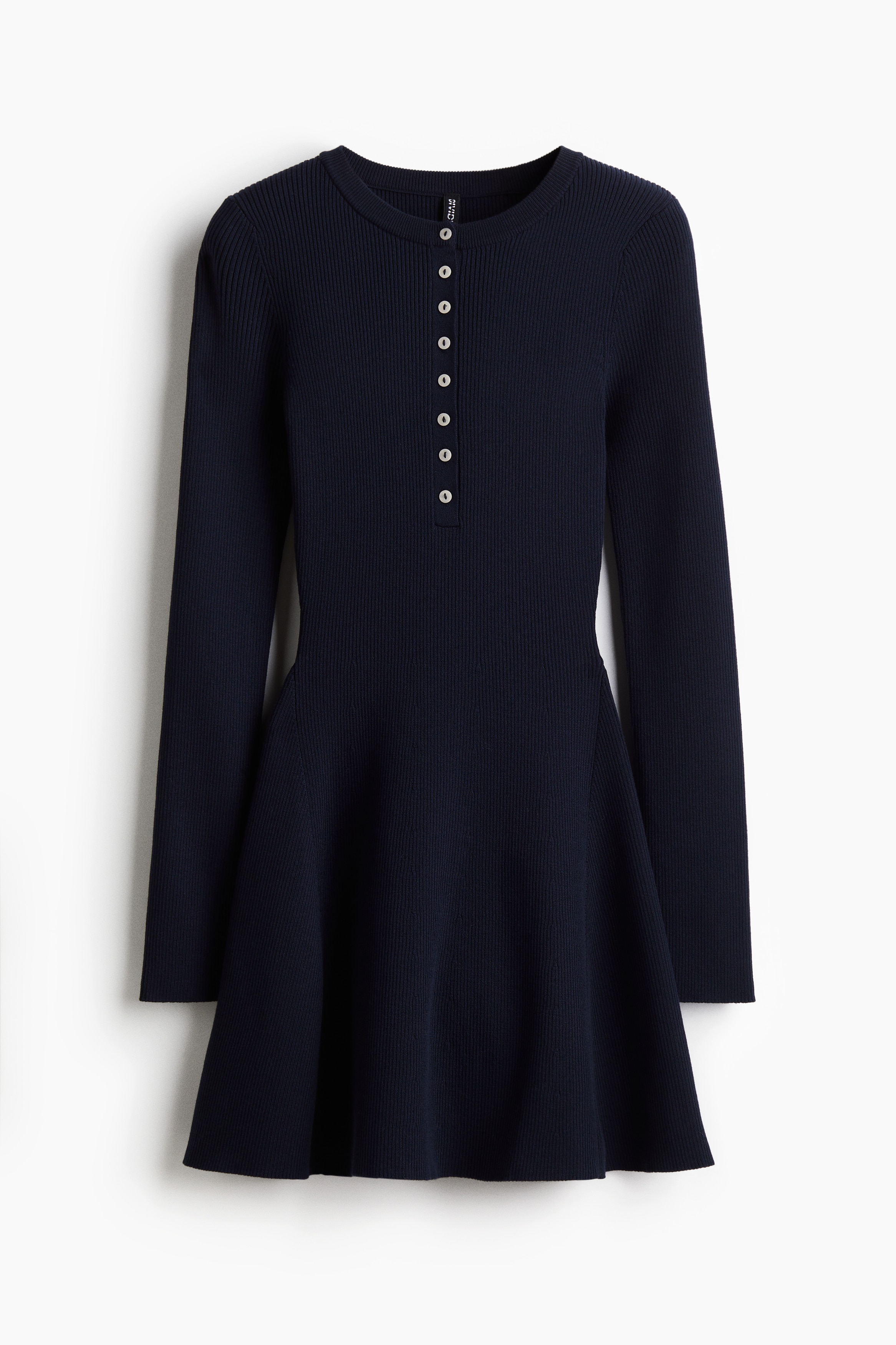 리브니트 소재의 라운드넥 미니 드레스. 상단 버튼. 긴소매. 보디스는 피트되며, 하단은 플레어 라인으로 마감됨. 이미지