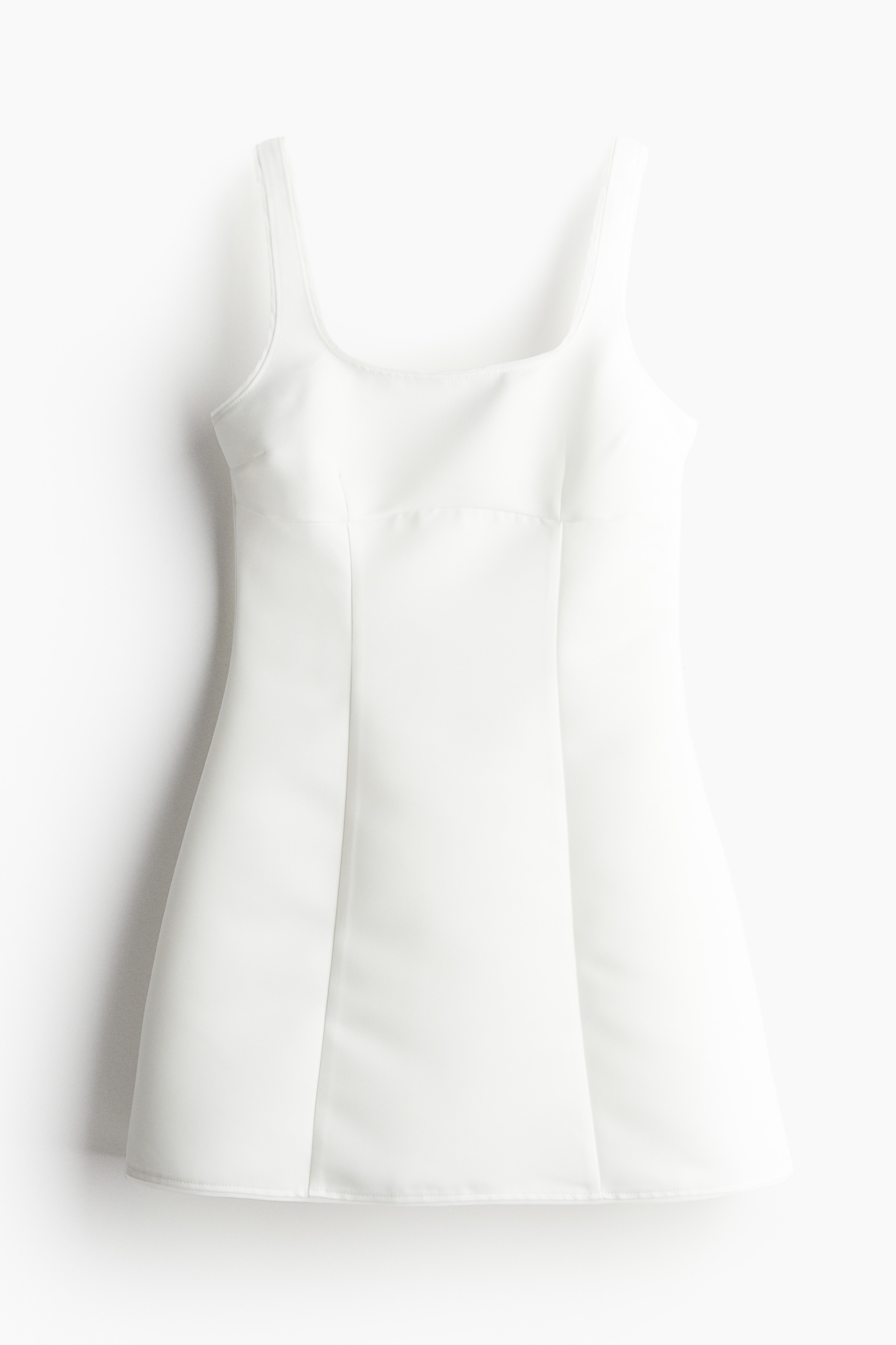 가슴 아래와 앞뒷면 솔기가 눈에 띄게 처리된 미니 원피스. 앞뒷면 U넥. 와이드한 어깨 스트랩. 피트되는 보디스. 한쪽 옆면 히든 지퍼 클로저. 플레어 라인. 안감 생략. 이미지