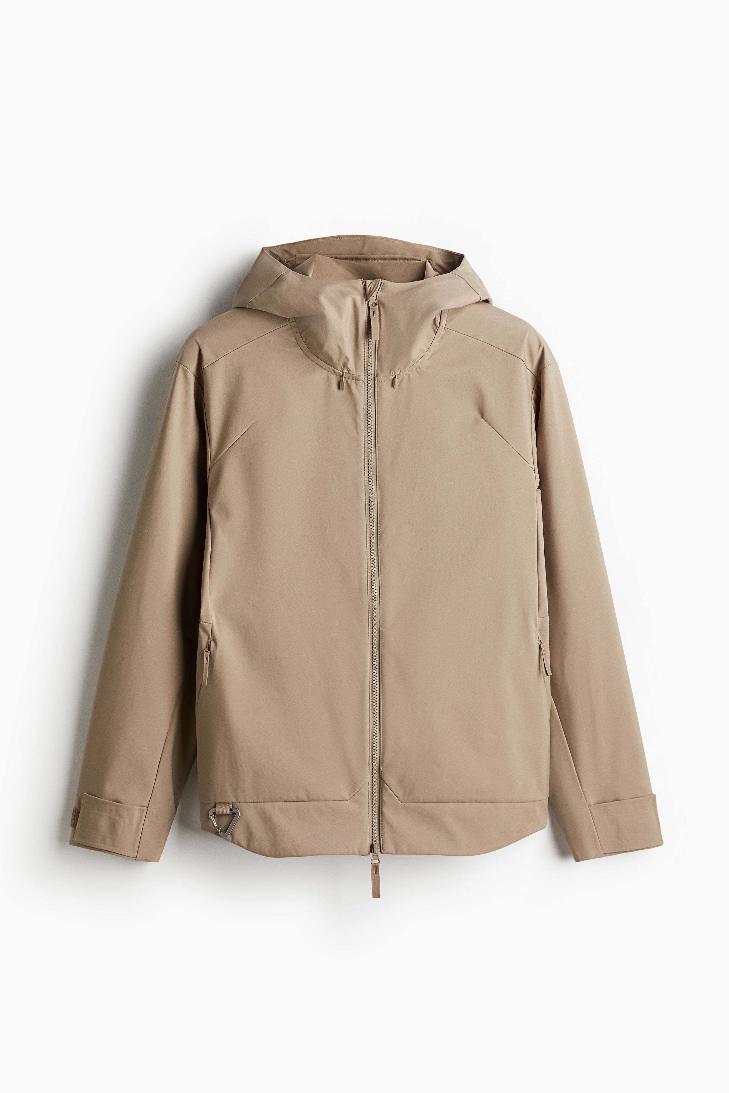 기능성 방풍, 발수 소재의 소프트쉘 재킷. 레귤러핏. 앞뒷면에 신축성 드로스트링이 내장되어 후드가 흘러내리지 않고 머리에 맞게 피트되는 디자인. 하이넥. 턱 부분에 쓸림 방지 덮개가 있는 지퍼 클로저. 고정되지 않은 뒷면 요크 부분에 통기성 메쉬 디테일이 있음. 긴소매. 테이프 스트랩으로 소맷단 핏 조절. 앞면 금속 카라비너 후크. 옆면 지퍼 포켓. 뒷면에 밴딩이 내장된 세미 라운드 헴라인. 안감 생략. 이미지