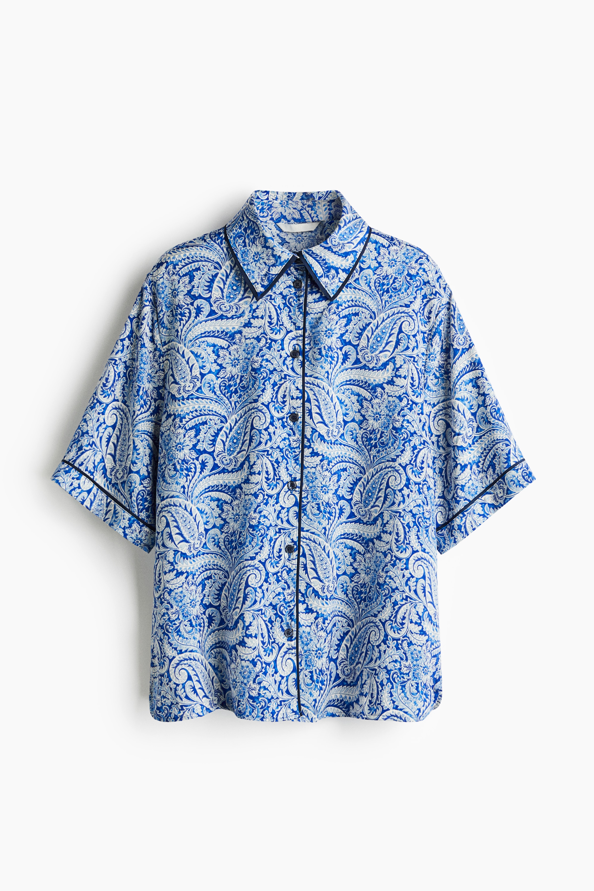 부드럽게 드레이핑되는 프린트 패턴 새틴 소재의 오버사이즈 셔츠. 포인트 컬러 파이핑 디테일. 칼라가 있는 버튼업 스타일. 5부 소매. 양쪽 옆면 하단에 짧은 트임이 있는 스트레이트 헴라인. 이미지