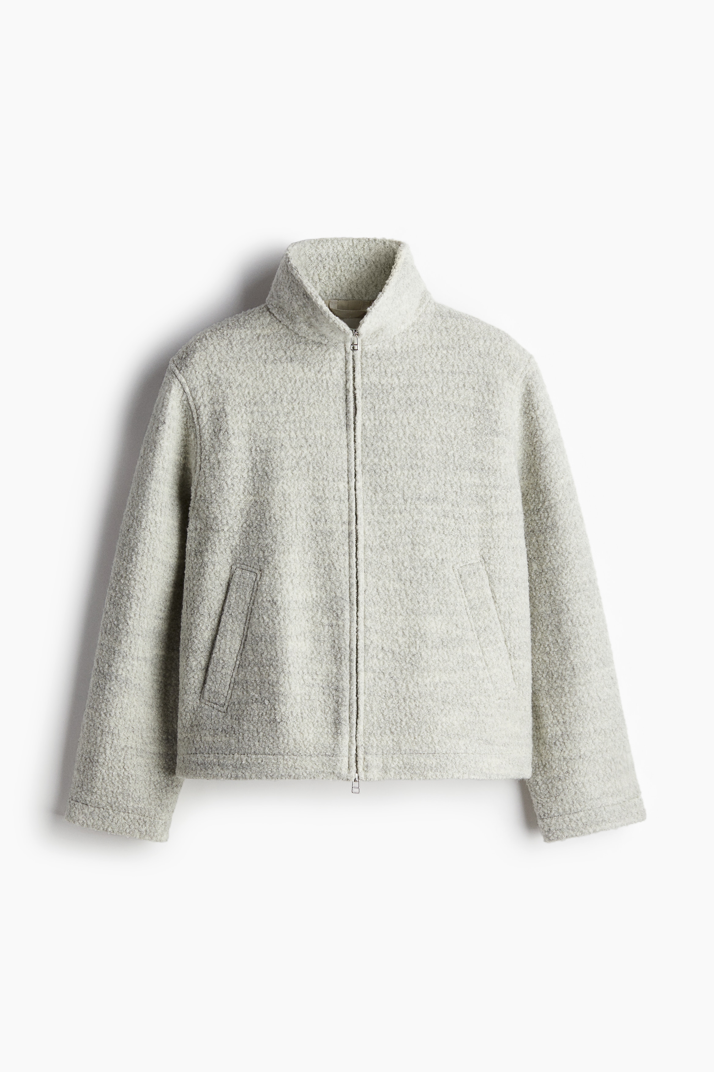 부드러운 울 혼방 부클레 소재의 짧은 재킷. 하이넥. 앞면 지퍼 클로징. 뒷면 요크. 스냅버튼으로 여닫는 사선 방향의 옆면 웰트포켓. 긴소매. 착용감이 편안하고 클래식한 레귤러핏 실루엣. 안감 부착. 이미지