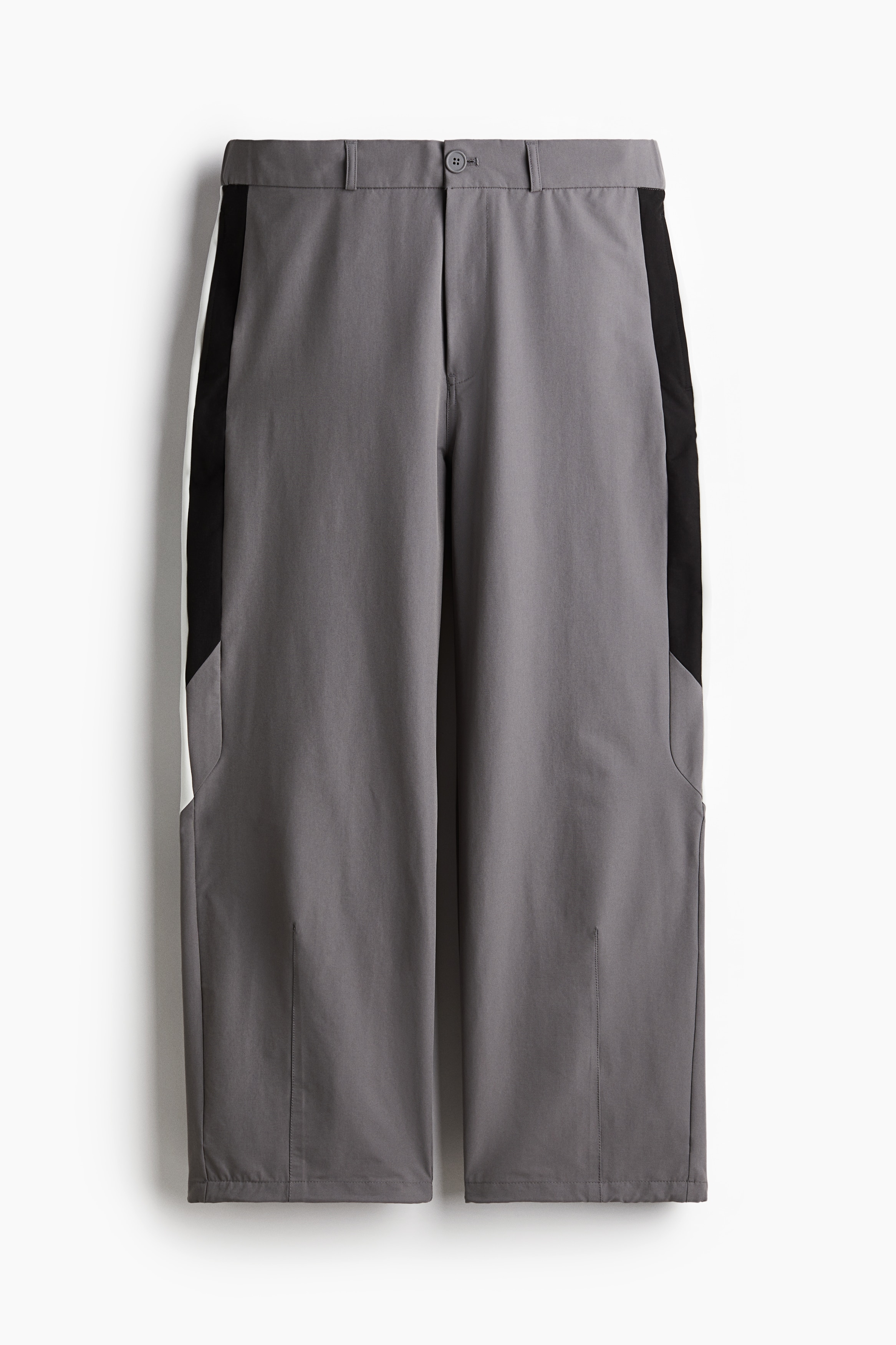 옆면 패널이 있는 우븐 소재의 팬츠. 신축성 허릿단. 지퍼와 버튼 클로징. 옆면 포켓, 뒷면 페이크 포켓. 신축성 드로스트링이 있는 아랫단. 넉넉하지만 오버사이즈보다는 약간 피트되는 루즈핏 실루엣. 이미지