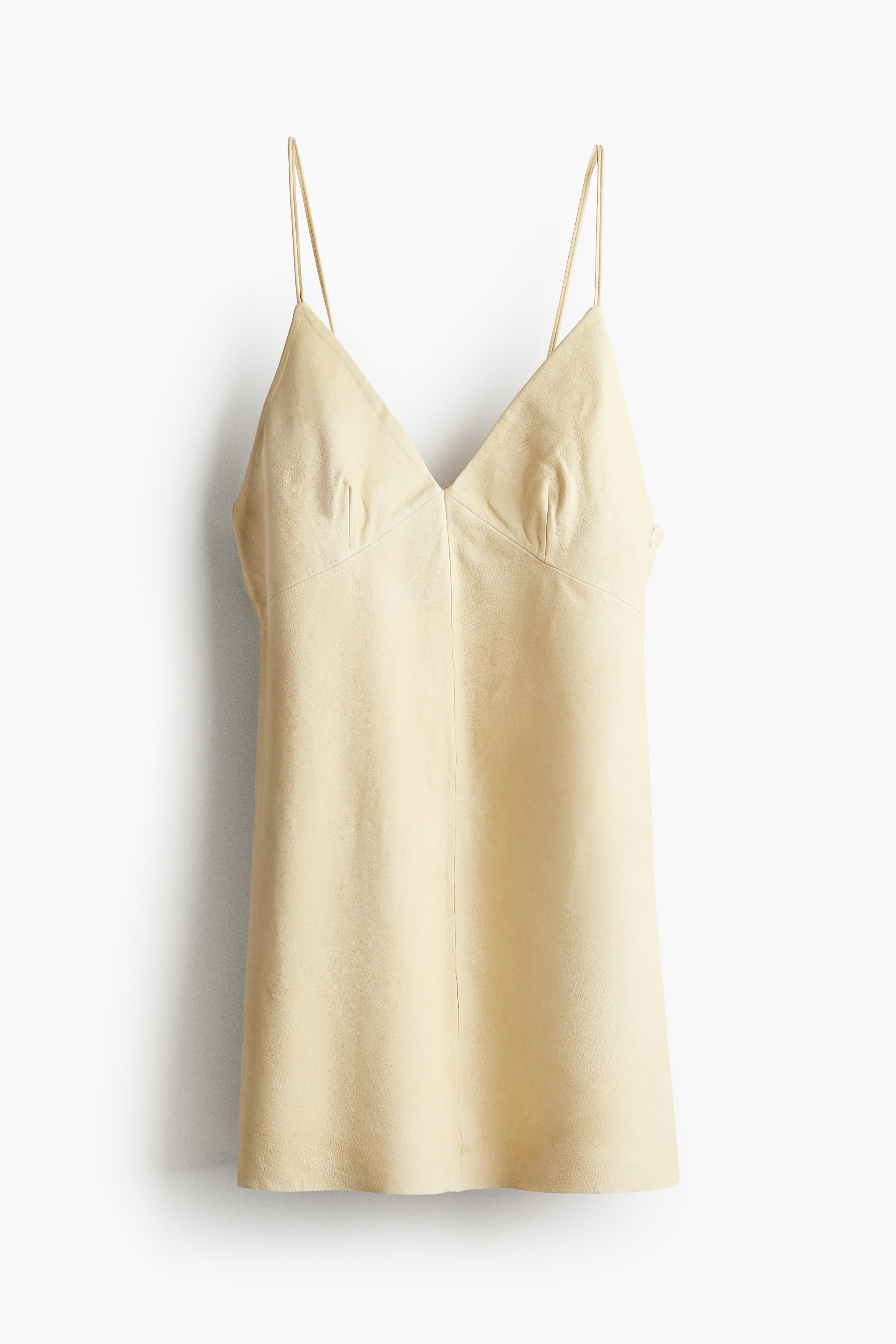 Studio Collection. 부드러운 가죽 소재의 세련된 미니 원피스. V넥. 길이 조절 가능한 가는 어깨 스트랩의 긴 끝을 뒷면의 작은 고리에 꿰어 매듭짓는 스타일. 뾰족한 모양의 가슴 아래 솔기. 완만한 A라인의 하단. 뒷면 히든 지퍼와 후크 클로저. 마감되지 않은 헴라인. 비스코스 안감 부착. 이미지